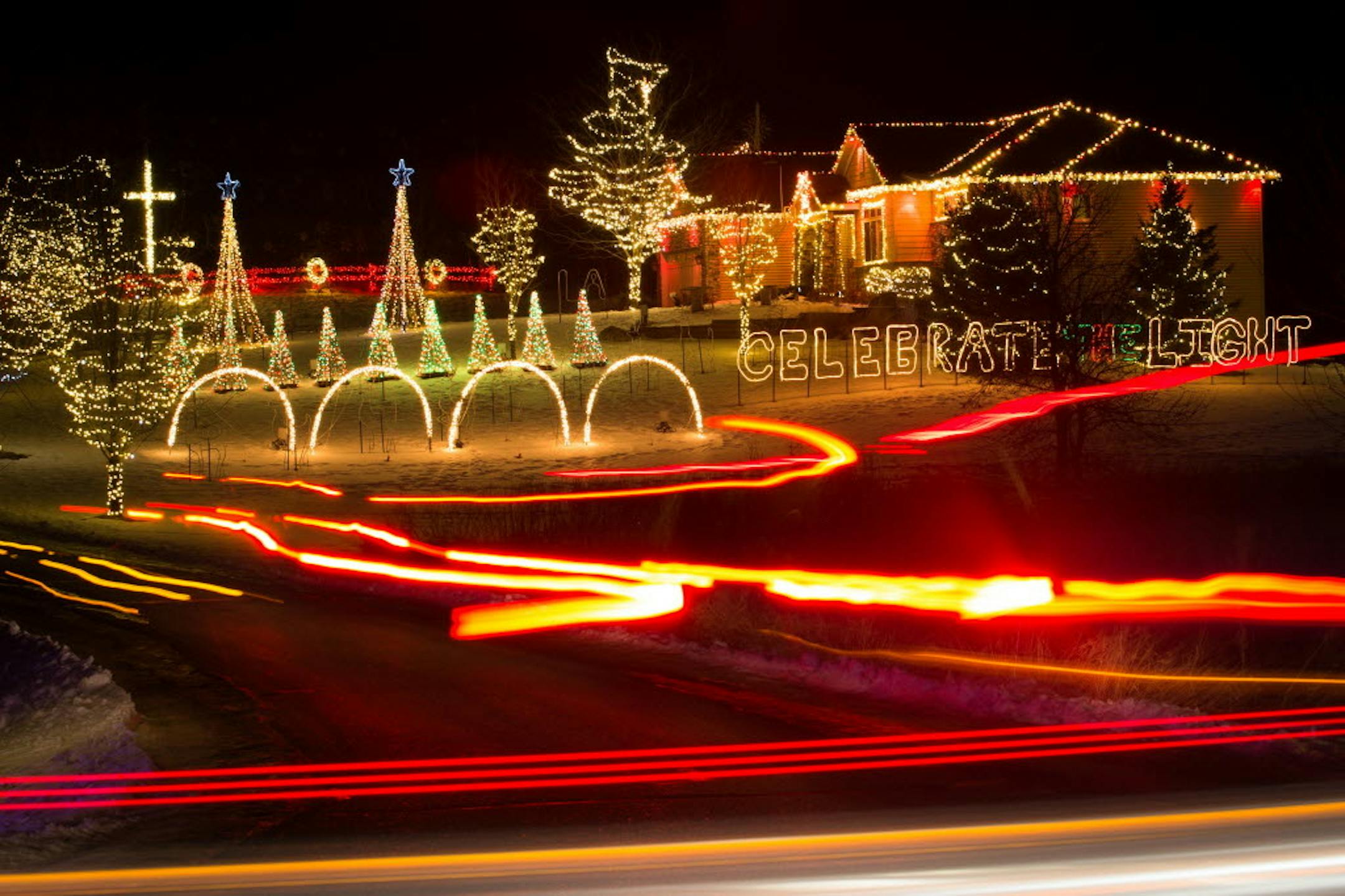 In 2014, the head and tail lights from visiting cars leave light trails as they drive through the Koosman family's property to see their elaborate Christmas light decorations.