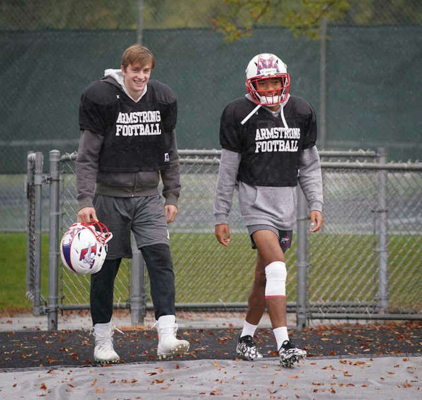 Armstrong quarterback Jake Breitbach (left) and Thai Bowman walked onto the field for team practice in the rain Tuesday afternoon. Photo: Shari L. Gross • shari.gross@startribune.com