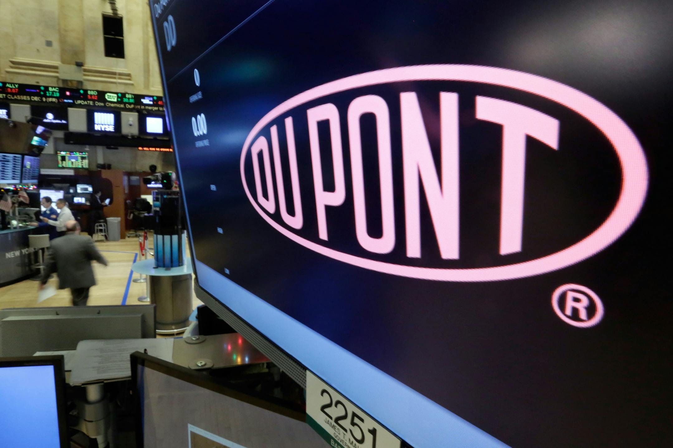 FILE - In this Dec. 9, 2015, file photo, the company name of Dupont appears above its trading post on the floor of the New York Stock Exchange. Dupont reports financial results Tuesday, Jan. 24, 2017. (AP Photo/Richard Drew, File)