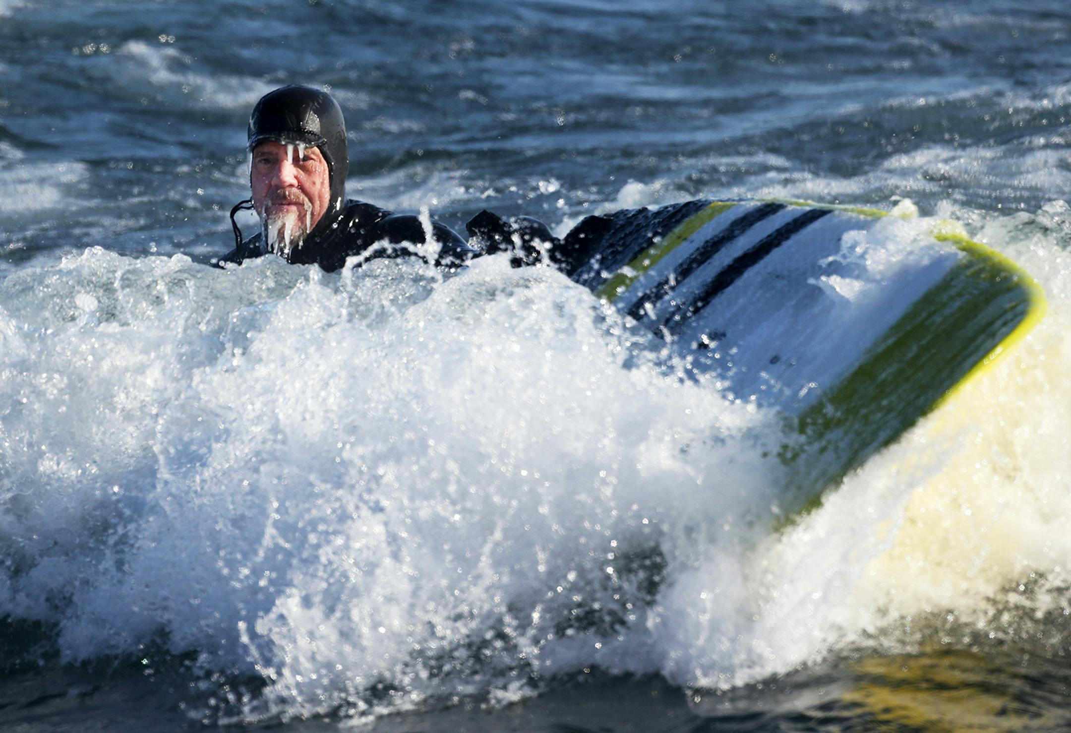 Surfer Randy Carlson of Duluth is coated in ice but happy after riding waves on New Year's Day on Stoney Point, Tuesday, January 1, 2019 in Two Harbors, Minnesota.