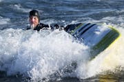 Surfer Randy Carlson of Duluth is coated in ice but happy after riding waves on New Year's Day on Stoney Point, Tuesday, January 1, 2019 in Two Harbor