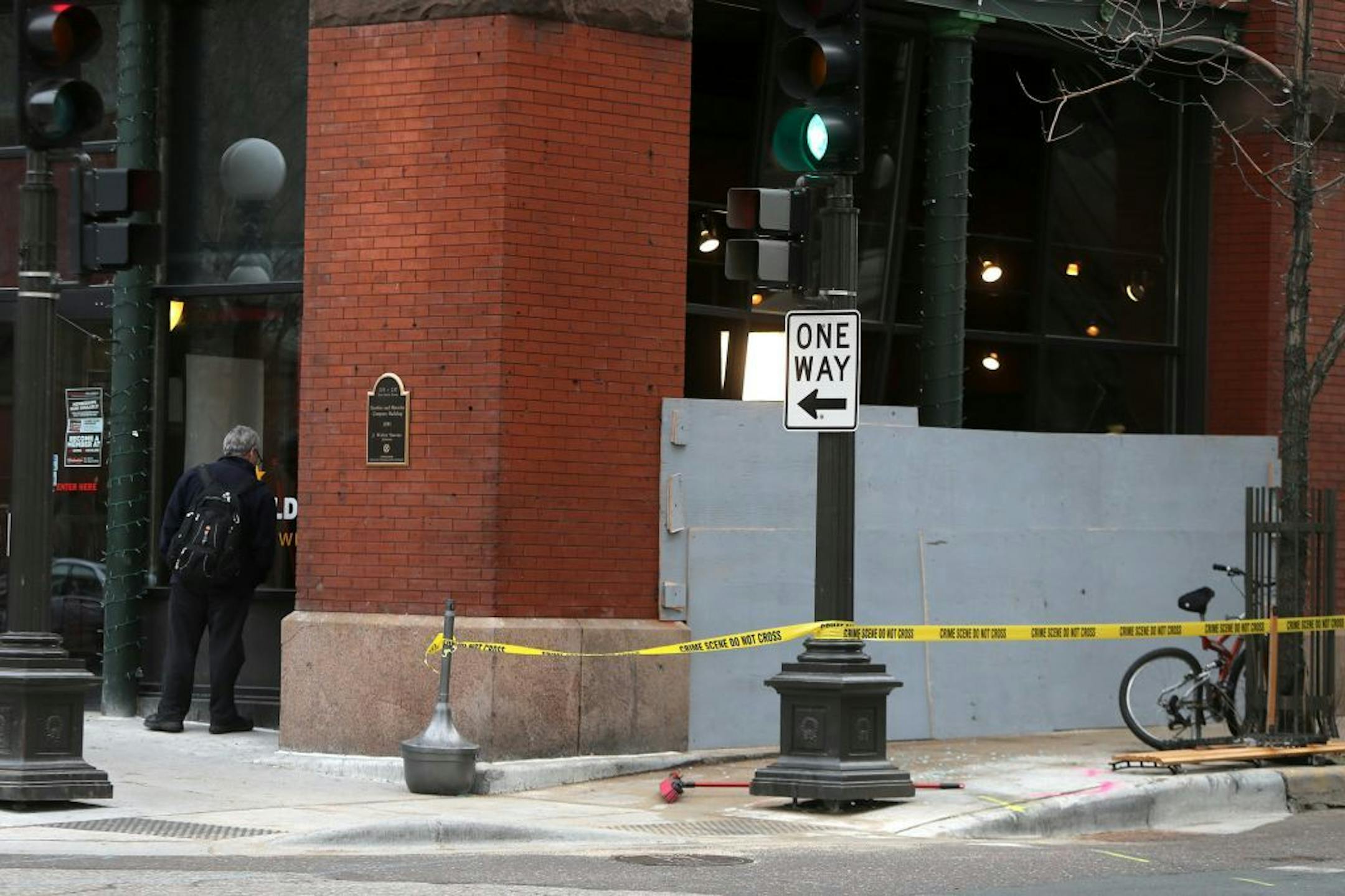 Pedestrians walking by look through the Bulldog scene where a car had crashed through.