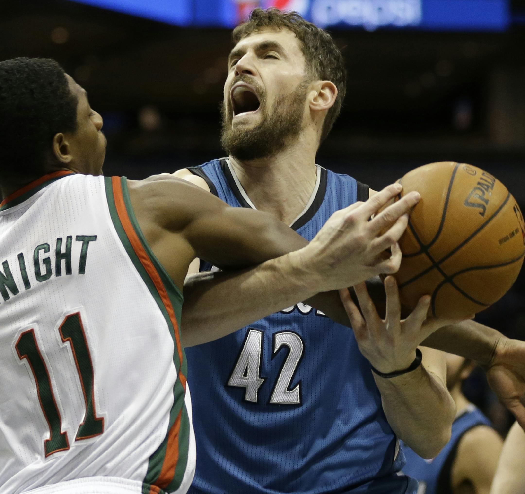 Milwaukee Bucks' Brandon Knight (11) fouls Minnesota Timberwolves' Kevin Love (42) during the first half of an NBA basketball game, Saturday, Dec. 28, 2013, in Milwaukee. (AP Photo/Jeffrey Phelps)
