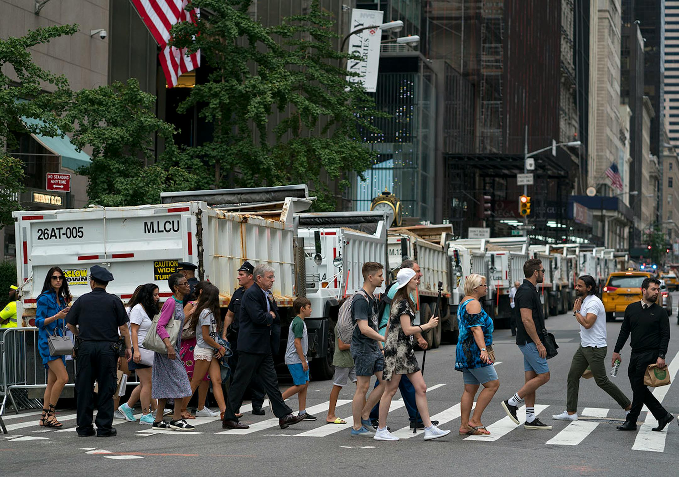 Trucks acting as security barriers form a line along 5th Ave., in New York Monday, Aug. 14, 2017, in anticipation of the arrival of President Donald Trump later in the evening.