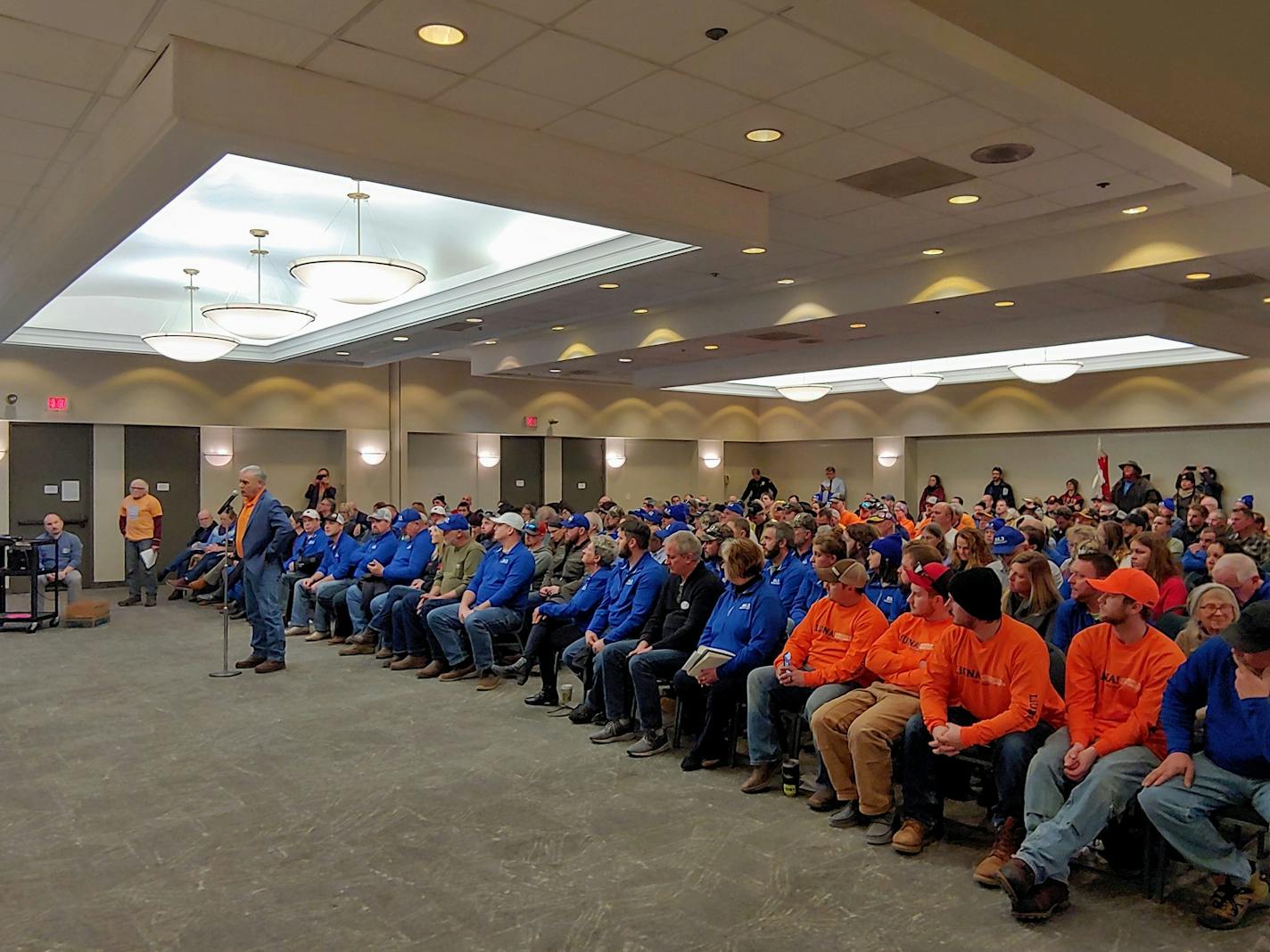 Dan Olson, business agent for LIUNA Local 1091, testifies in favor of the Enbridge Line 3 replacement pipeline at a state hearing Thursday in Duluth while flanked by project supporters in blue and orange.