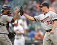 Minnesota Twins relief pitcher Tommy Milone (33) celebrates 4-3 win in 12 innings over the Baltimore Orioles with catcher Kurt Suzuki, left, after a b