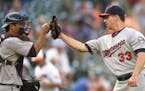Minnesota Twins relief pitcher Tommy Milone (33) celebrates 4-3 win in 12 innings over the Baltimore Orioles with catcher Kurt Suzuki, left, after a b