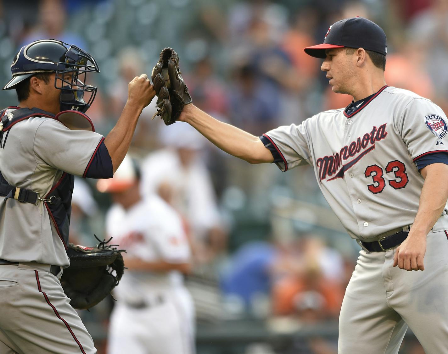 Minnesota Twins relief pitcher Tommy Milone (33) celebrates 4-3 win in 12 innings over the Baltimore Orioles with catcher Kurt Suzuki, left, after a baseball game, Sunday, Aug. 23, 2015, in Baltimore. (AP Photo/Nick Wass)