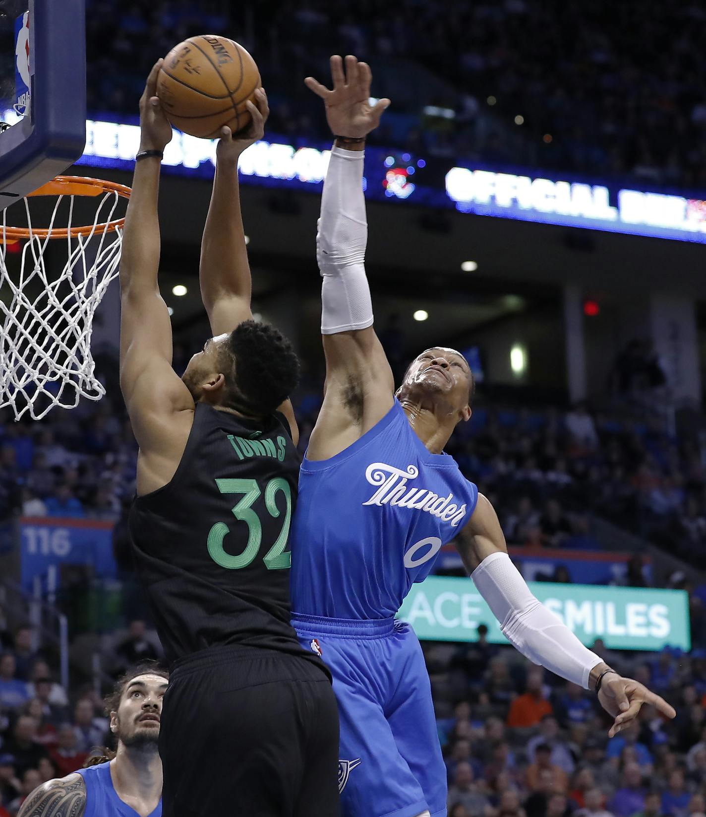 Minnesota Timberwolves center Karl-Anthony Towns (32) goes to the basket as Oklahoma City Thunder guard Russell Westbrook (0) defends during the first half of an NBA basketball game in Oklahoma City, Sunday, Dec. 25, 2016. (AP Photo/Alonzo Adams)