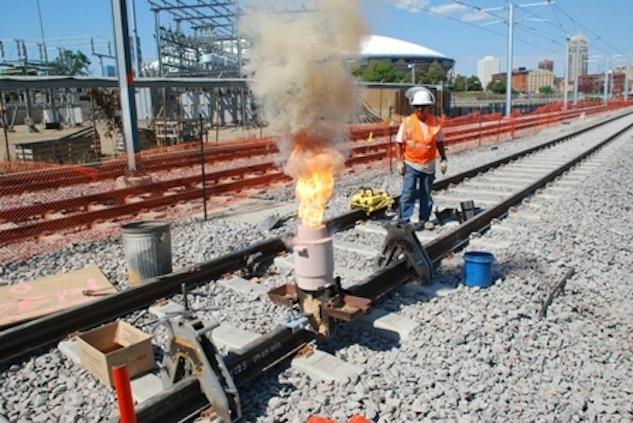 Welder Miguel Ayala of Herzog Contracting Corp. stands back as flames shoot briefly from the weld. (photo courtesy of Metropolitan Council)