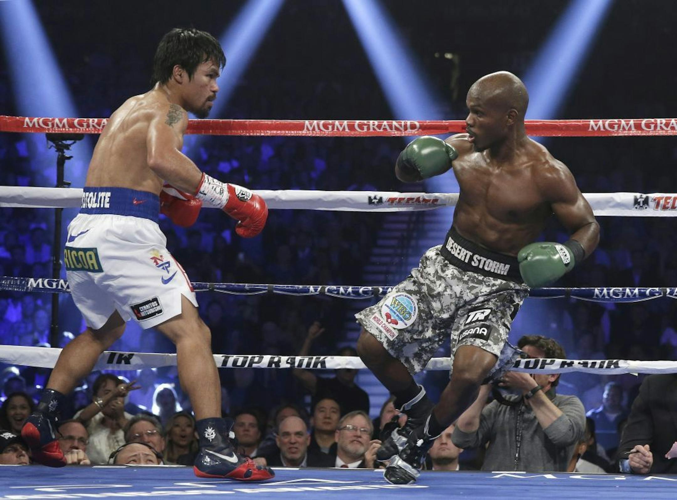 Timothy Bradley, right, loses his footing in front of Manny Pacquiao, of the Philippines, in their WBO welterweight title boxing fight Saturday, April 12, 2014, in Las Vegas.