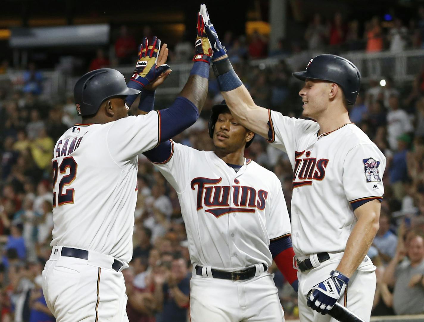 Minnesota Twins' Miguel Sano, left, celebrates celebrates his two-run home run off Pittsburgh Pirates pitcher Richard Rodriguez with Jorge Polanco, center, and Max Kepler in the eighth inning of a baseball game Tuesday, Aug. 14, 2018, in Minneapolis. The Twins won 5-2. (AP Photo/Jim Mone)