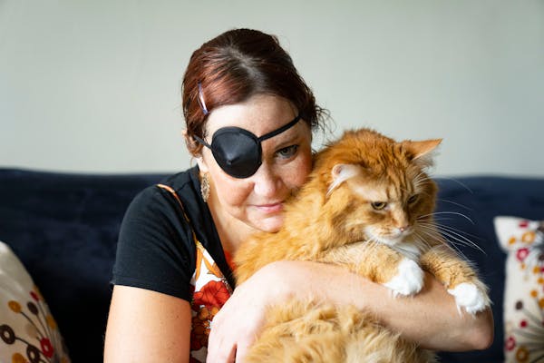 Betsy Graca works on getting her cannabis certification while cuddling her cat, Bumby, at home in Minneapolis.