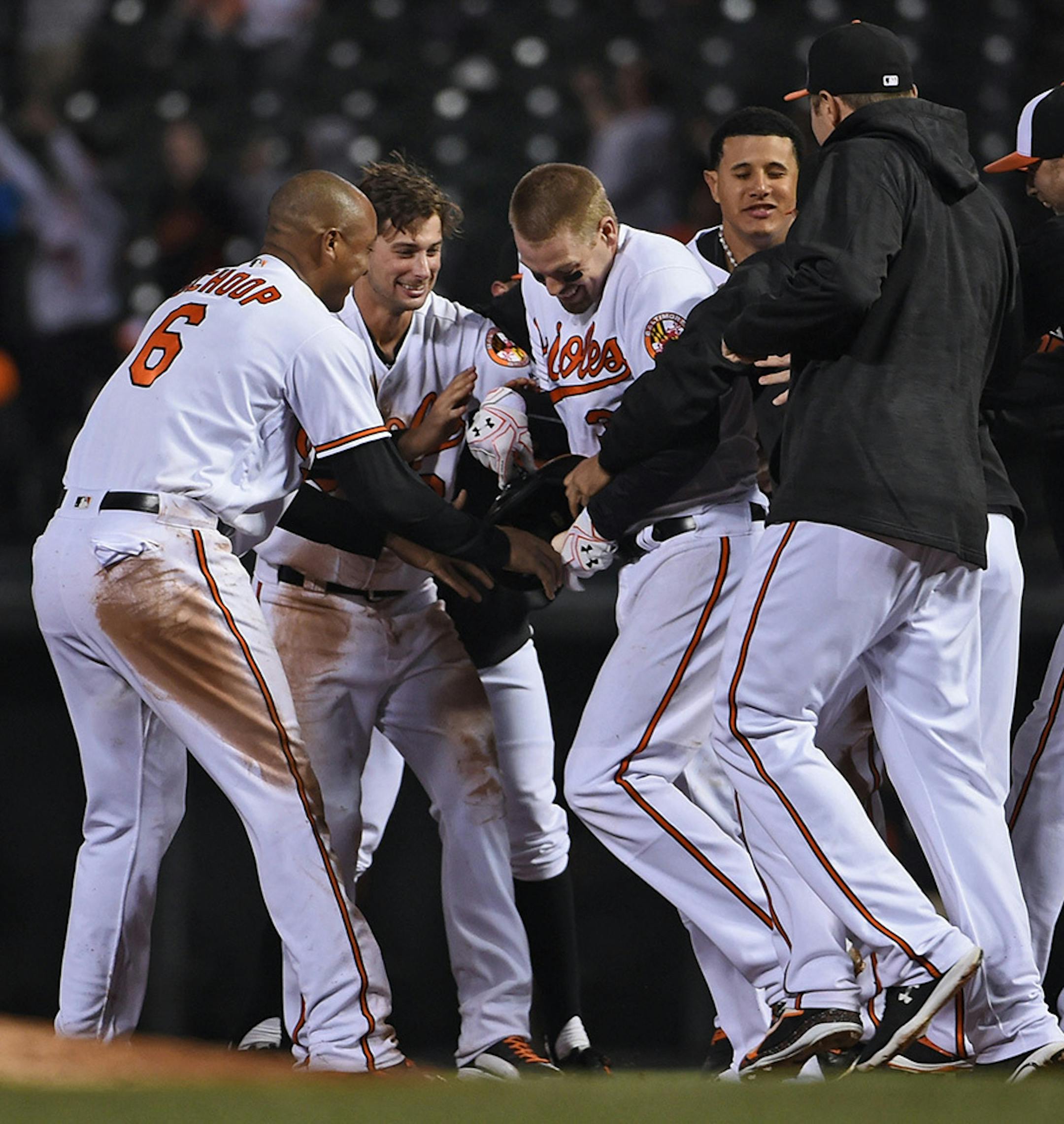 Baltimore Orioles players mob teammate Matt Wieters, center, in celebration after his game-winning single during the ninth inning on Monday, April 4, 2016, at Oriole Park at Camden Yards in Baltimore.