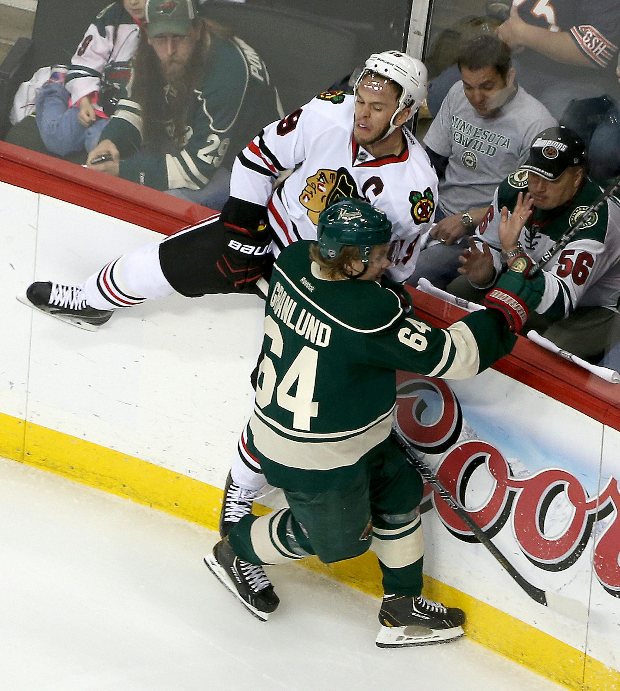 Minnesota Wild center Mikael Granlund (64) checked Chicago Blackhawks center Jonathan Toews (19) into the boards in the first period in game six of round two of the Stanley Cup Playoffs, Tuesday, May 13, 2014 at the Xcel Energy Center in St. Paul, MN. ] (ELIZABETH FLORES/STAR TRIBUNE) ELIZABETH FLORES • eflores@startribune.com