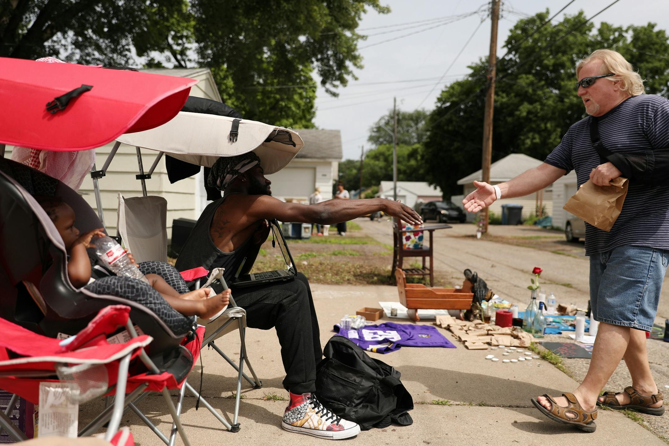 Jerome Peters Jr. greeted Denny Johnson, whose son lives nearby, as he visited a memorial in the alley where Thurman Blevins was killed by a Minneapolis police officer earlier in the week.