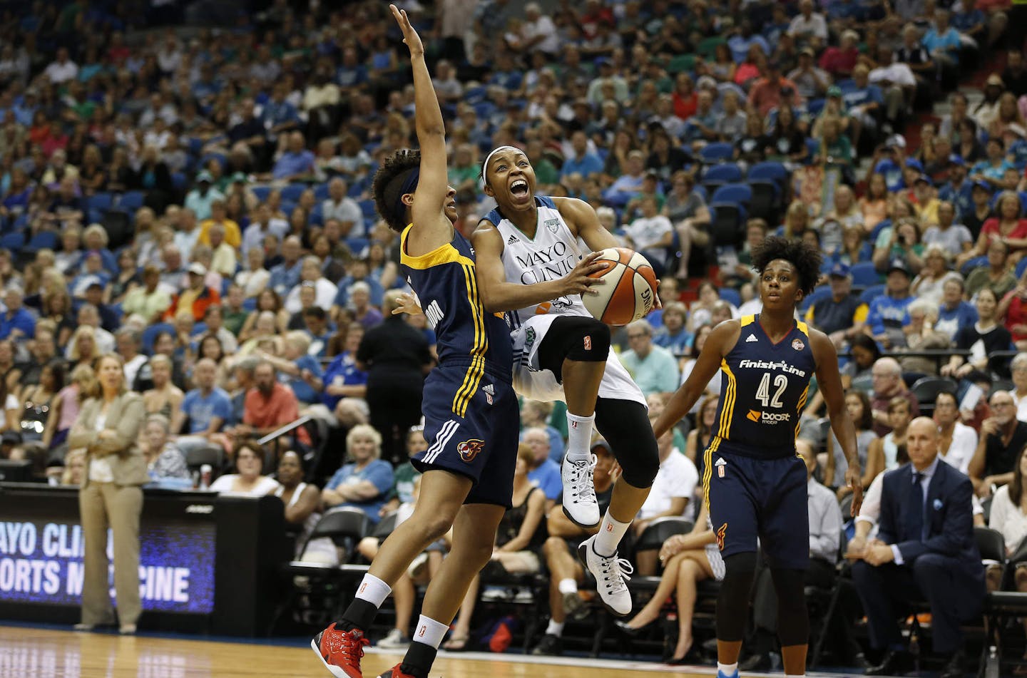 Minnesota Lynx guard Renee Montgomery (21) drives between Indiana Fever guard Layshia Clarendon, left, and guard Shenise Johnson (42) during the first half of a WNBA basketball game, Friday, Sept. 4, 2015, in Minneapolis. (AP Photo/Stacy Bengs)