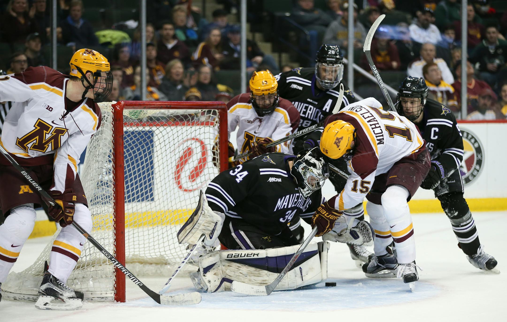 Gophers forward A.J. Michaelson (15) tried to get to the loose puck in front of Minnesota State Mankato goalie Cole Huggins (34) in the second period Sunday afternoon. The Mavericks defeated the Gophers 3-2 in the North Star College Cup consolation game.