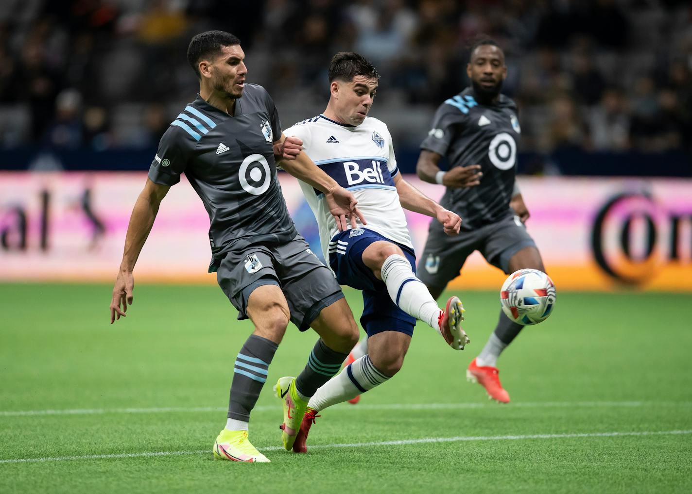 Vancouver Whitecaps' Brian White, front right, takes a shot on goal as Minnesota United's Michael Boxall, front left, defends before Minnesota put the ball in their net for an own goal during the first half of a MLS soccer game, Wednesday, Oct. 27, 2021 in Vancouver, British, Columbia. (Darryl Dyck/The Canadian Press via AP)