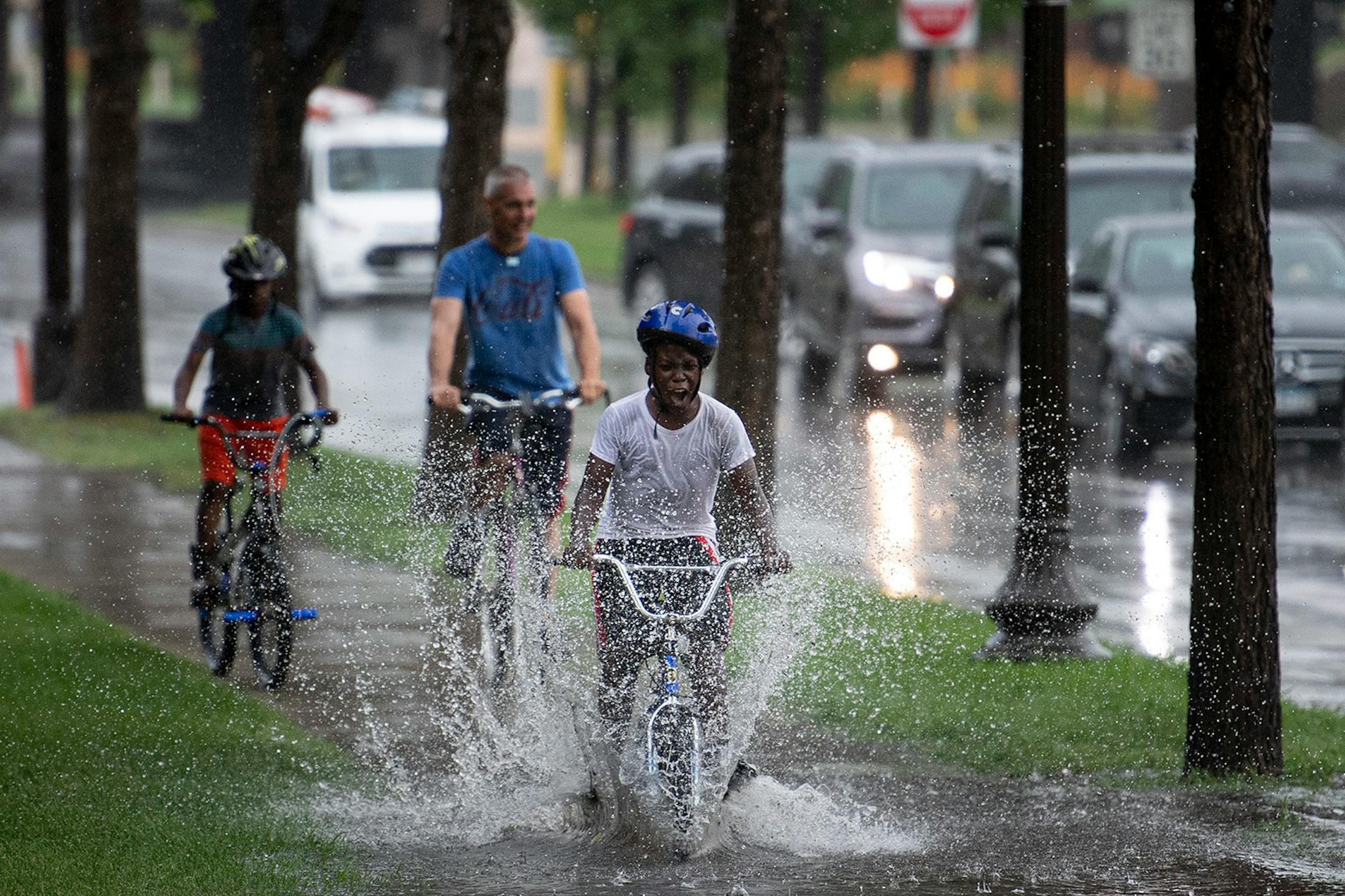 Cornell Smith, 11, paddled fast through flooding along Dunwoody Boulevard on Tuesday, July 16, 2019 en route to a Twins game at Target Field.