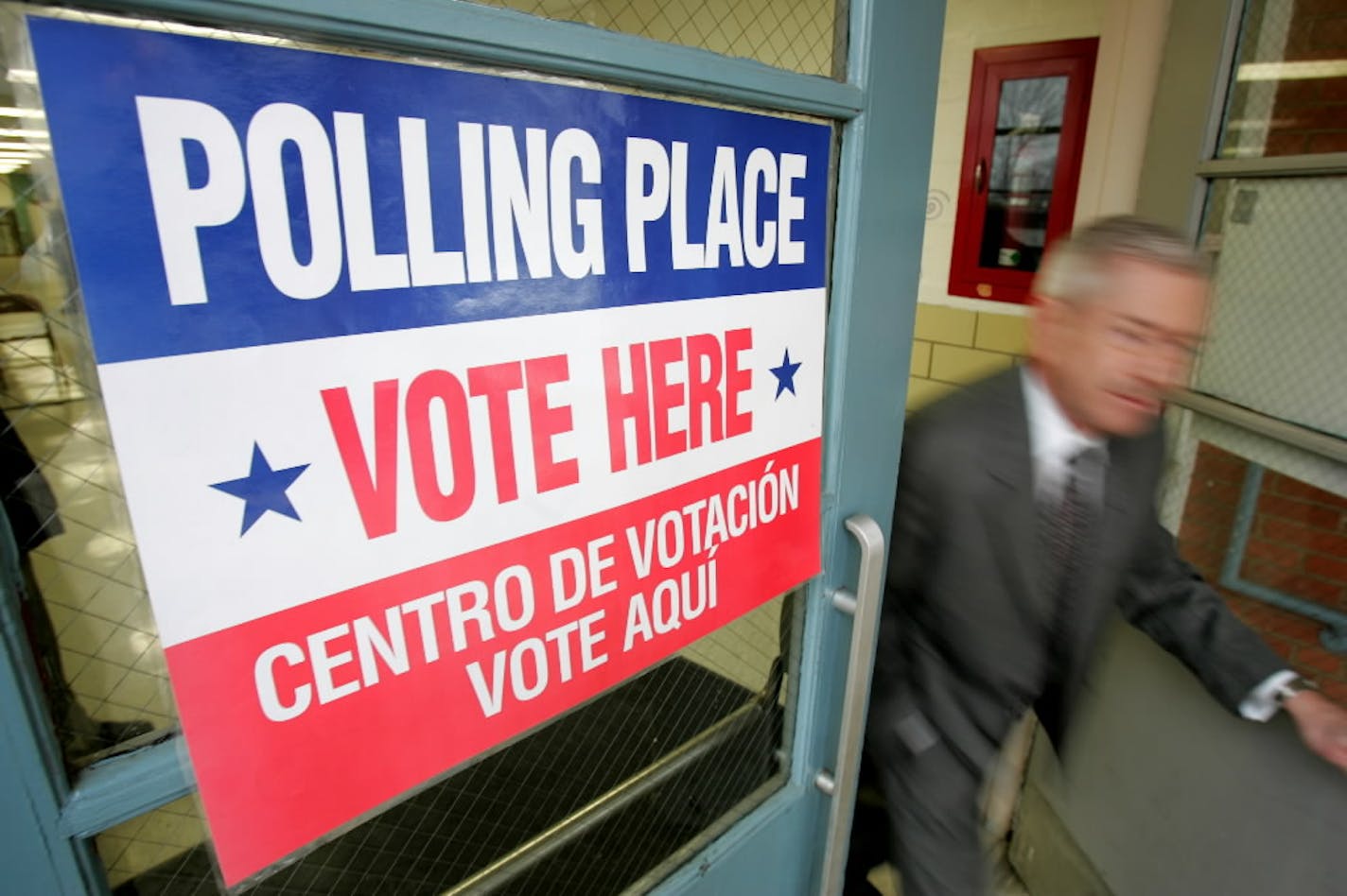 A man exits after voting in Tuesday's primary election at the Wilson School, a polling place in Arlington, Va.