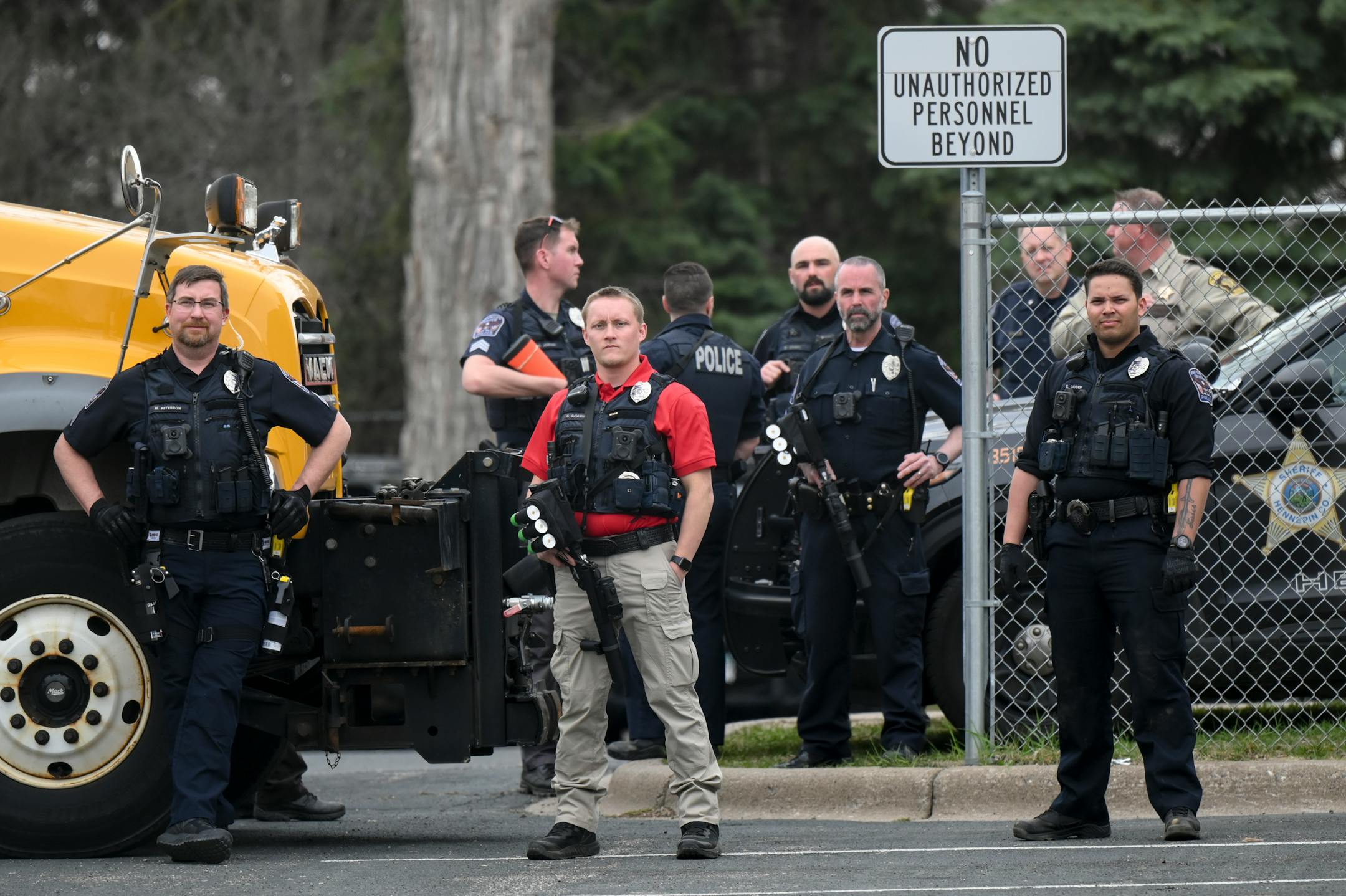 Brooklyn Center Police and Hennepin County Sheriffs deputies watch a small group of protesters outside the police station while armed with 40mm launchers and less lethal rounds.