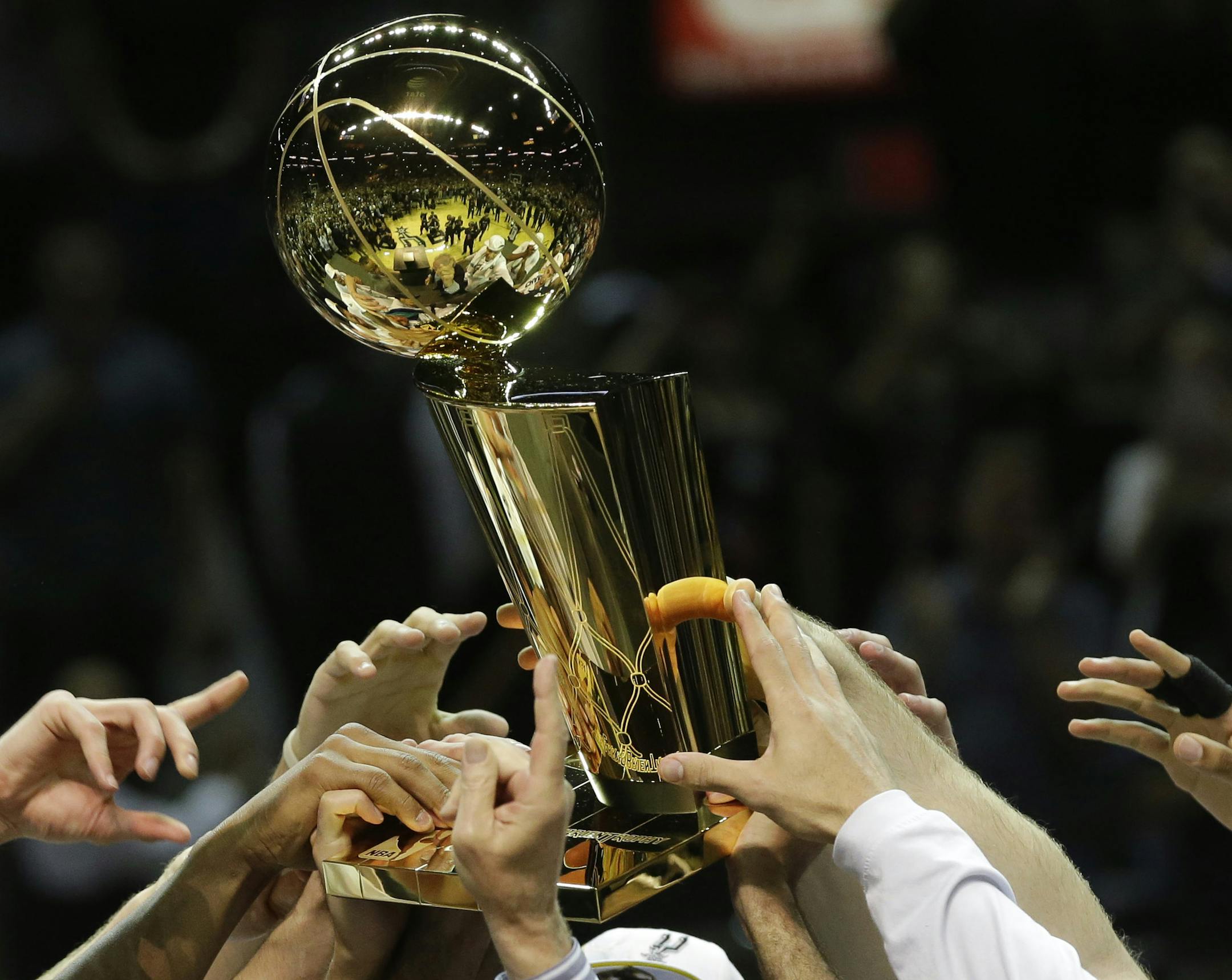 The San Antonio Spurs lift the Larry O'Brien NBA Championship Trophy after Game 5 of the NBA basketball finals on Sunday, June 15, 2014, in San Antonio. The Spurs won the NBA championship 104-87. (AP Photo/David J. Phillip) ORG XMIT: TXKJ182