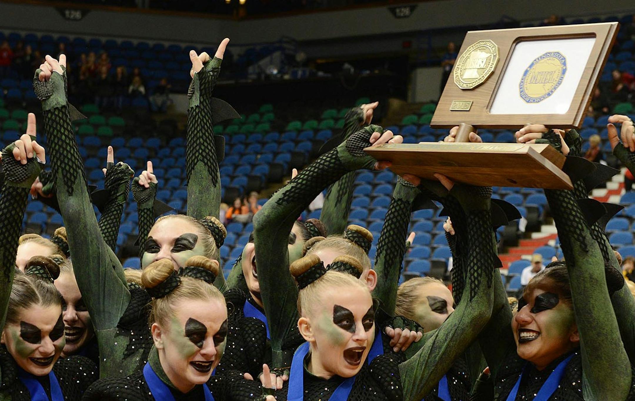 Faribault Emeralds dance team celebrates their announcement of first place in the 3AAA state dance team high kick division tournament by cheering and holding up their trophy on Feb. 14 at Target Center.