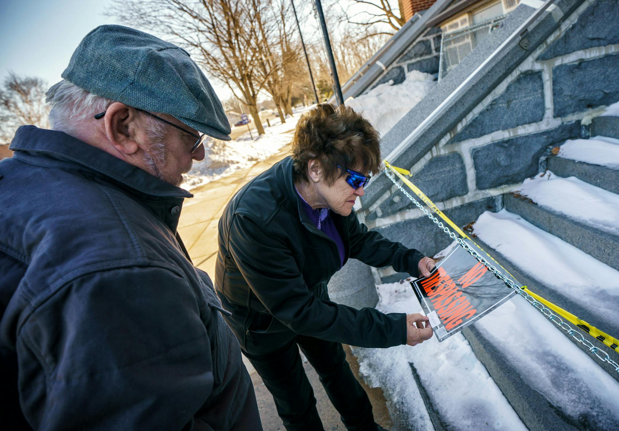 Jesse Lovelace and Bridgett Salzmann tried to read the signature on the "no trespassing" sign in front of the fire-damaged and fenced-in Church of St. Mary in Melrose.