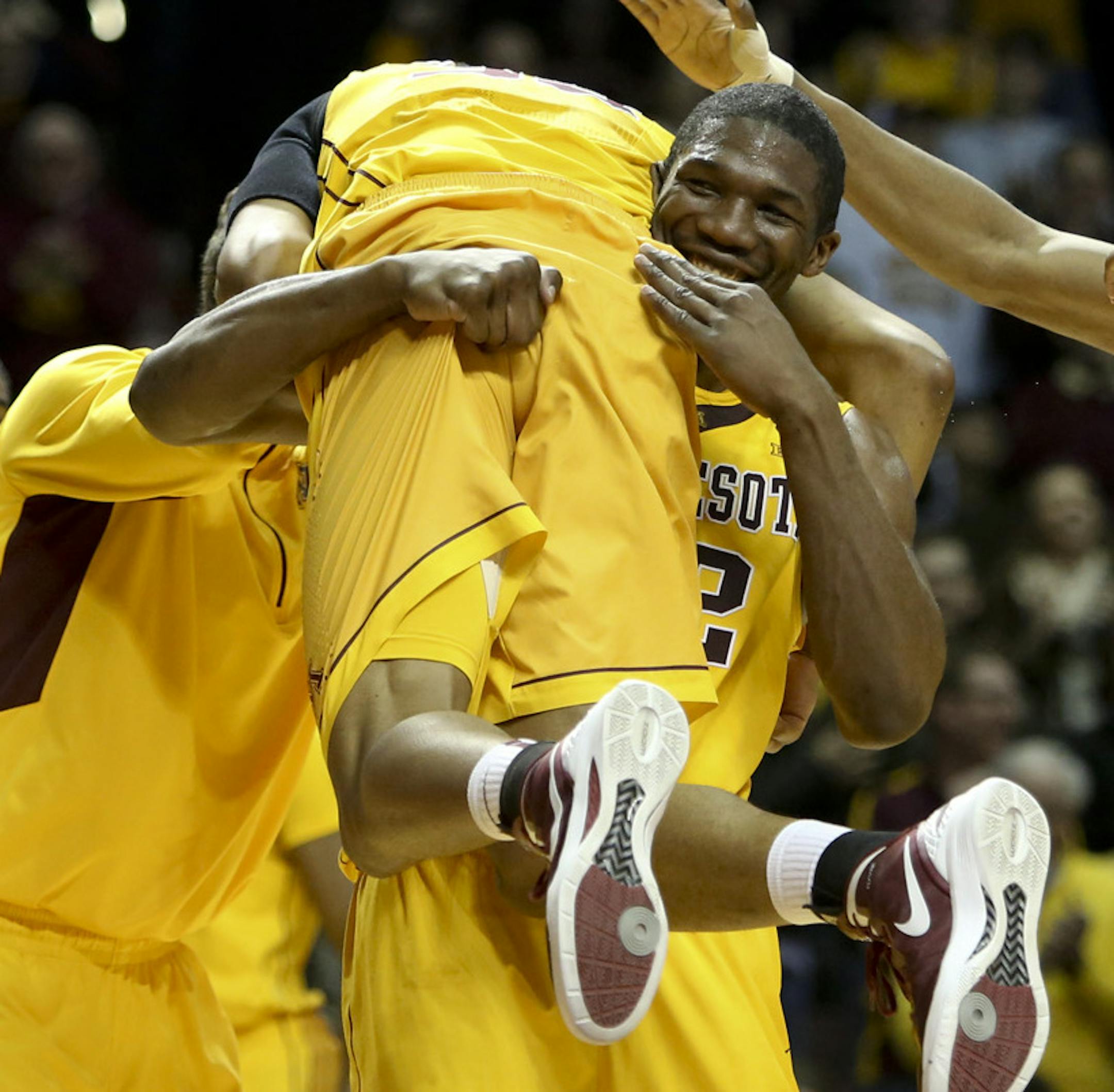 Gopher’s Trevor Mbakwe picked up teammate Rodney Williams Jr. during a timeout
