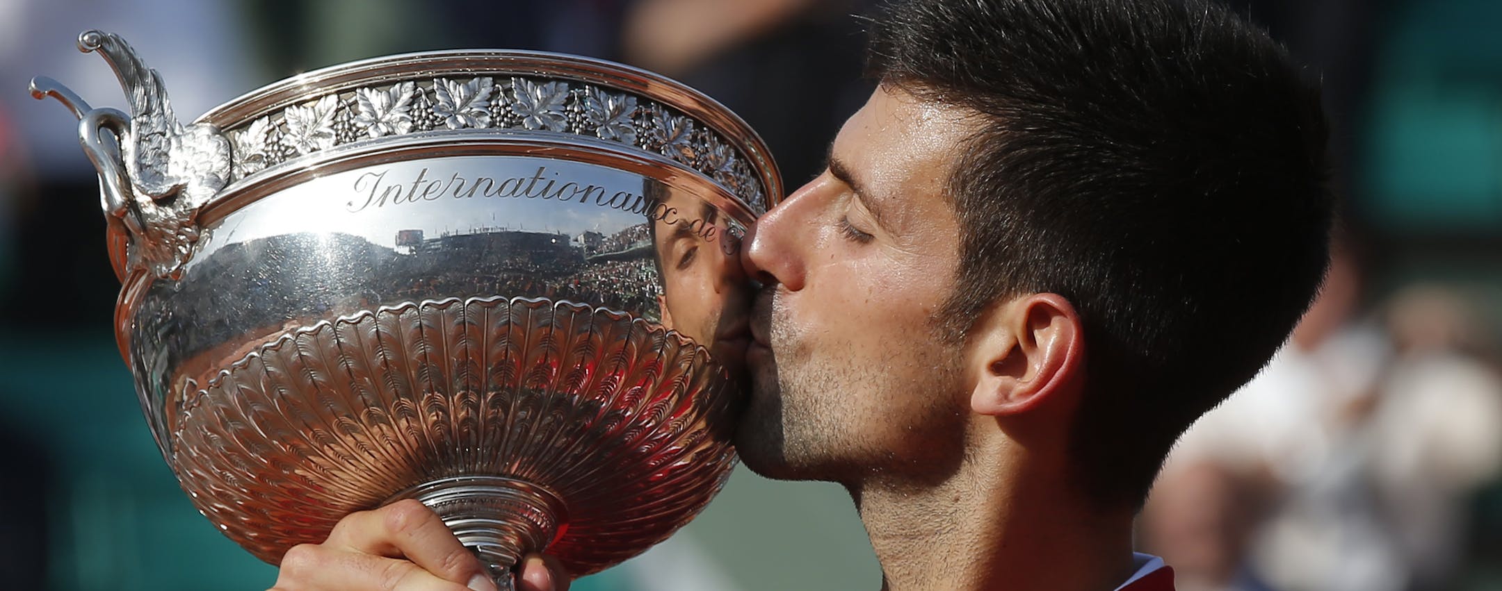 Serbia's Novak Djokovic kisses the trophy after winning the final of the French Open tennis tournament against Britain's Andy Murray in four sets 3-6, 6-1, 6-2, 6-4, at the Roland Garros stadium in Paris, France, Sunday, June 5, 2016. (AP Photo/Michel Euler)