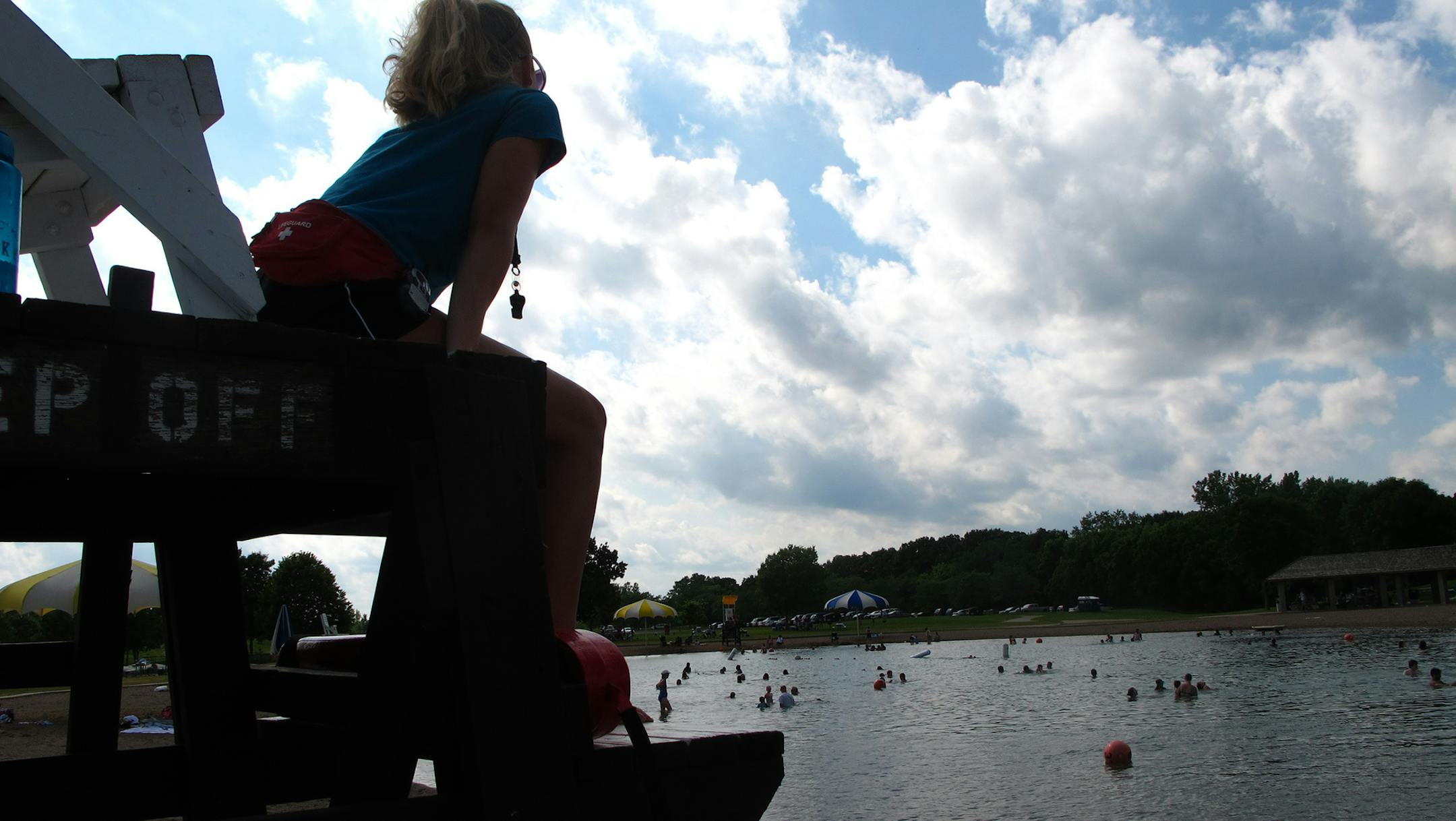 Christina Bordstrom, 18, a lifeguard at the Lake Elmo Park Reserve swim pond, watches over swimmers during a lazy summer afternoon last week. ‚ÄúYou meet lots of interesting people and spend lots of time outside,‚Äù said Bordstrom, of St. Paul, who is working her second summer as a lifeguard at the Lake Elmo beach. She has participated in about 30 rescues of distressed swimmers and searches for missing children, she said. The Lake Elmo beach is built around an a
