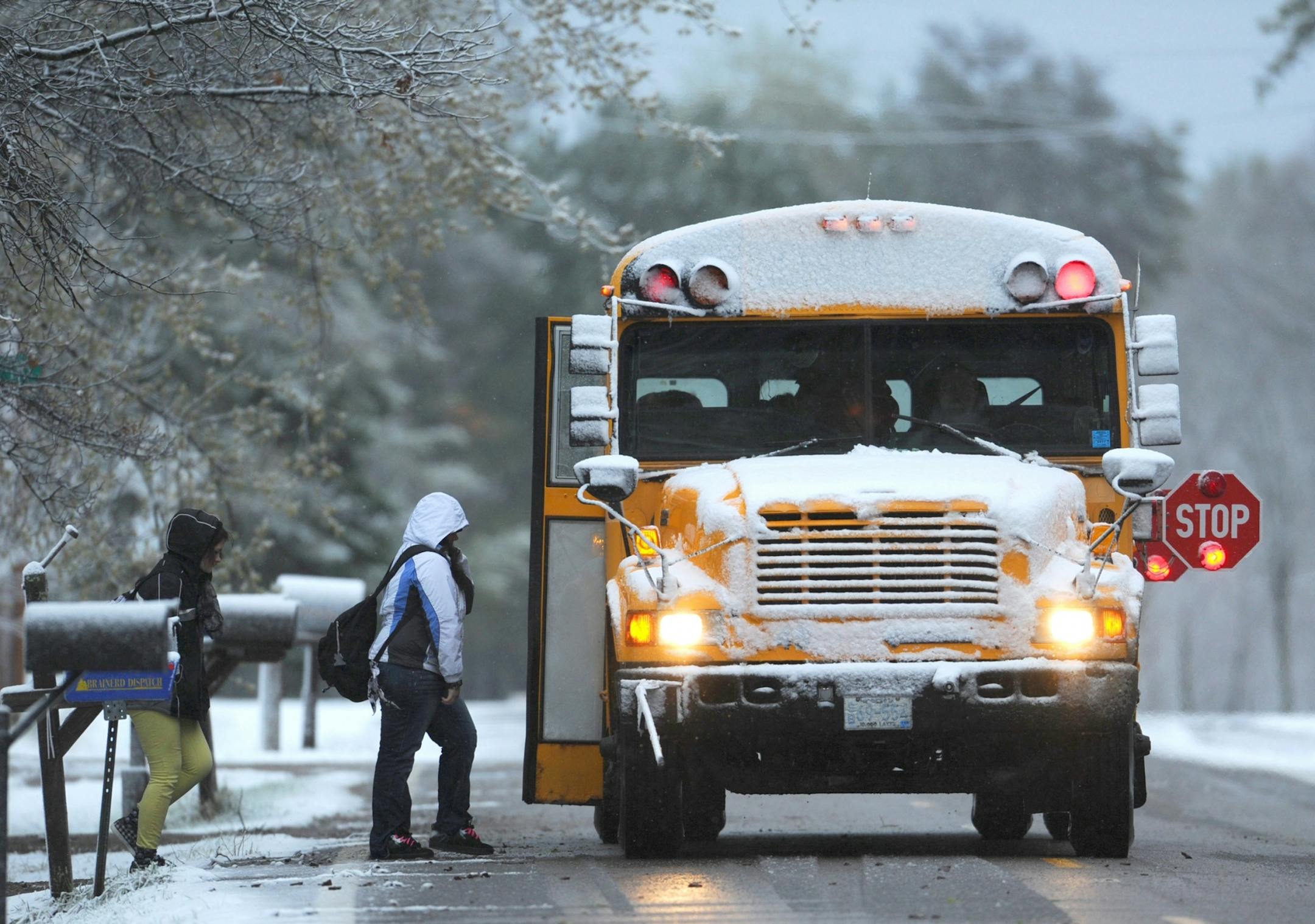 Brainerd High School students board a school bus Monday, April 16, 2012, in Brainerd, Minn., after central Minnesota was blanketed with snow overnight.