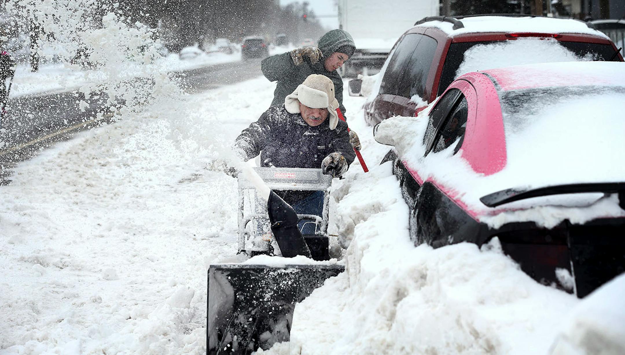 Alfonso Velez, in front, and his son Mark Velez, 15, plowed around cars Sunday in the 2100 block of Portland Avenue in Minneapolis.