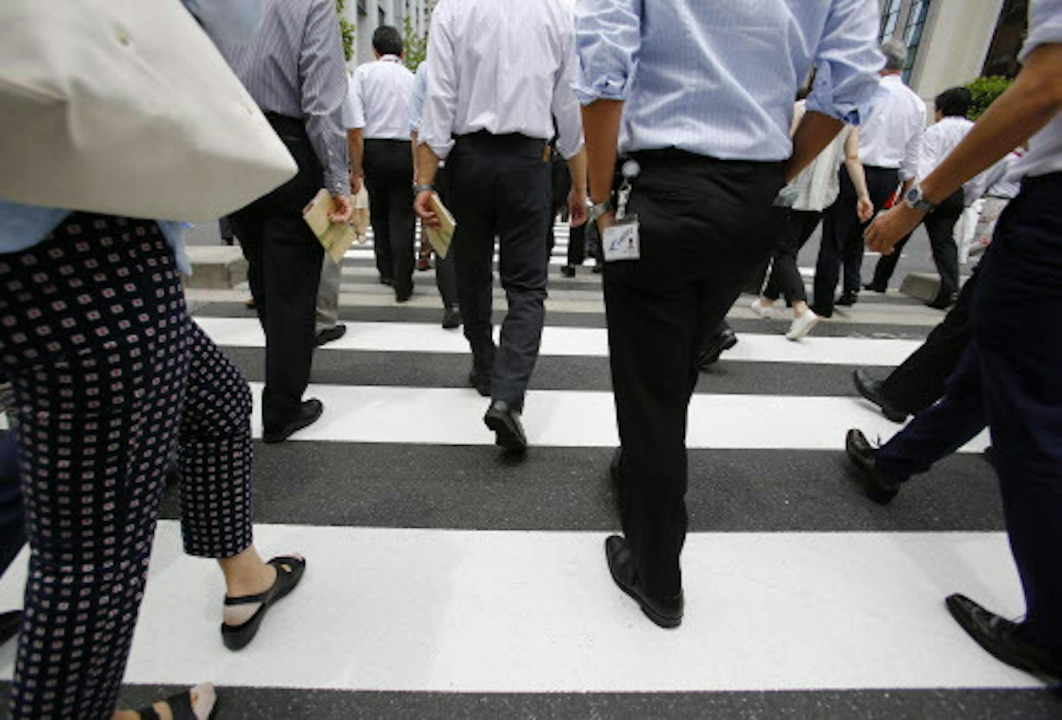 Office workers walk on a pedestrian crossing during a lunch break in Tokyo Monday, June 8, 2015. Japan's economy grew at a faster pace than initially estimated in the January-March quarter on stronger consumer and corporate spending, though economists anticipate slower growth in April-June. The 3.9 percent annualized growth rate announced Monday by the Cabinet Office was sharply higher than the 2.4 percent pace initially reported. (AP Photo/Shizuo Kambayashi)