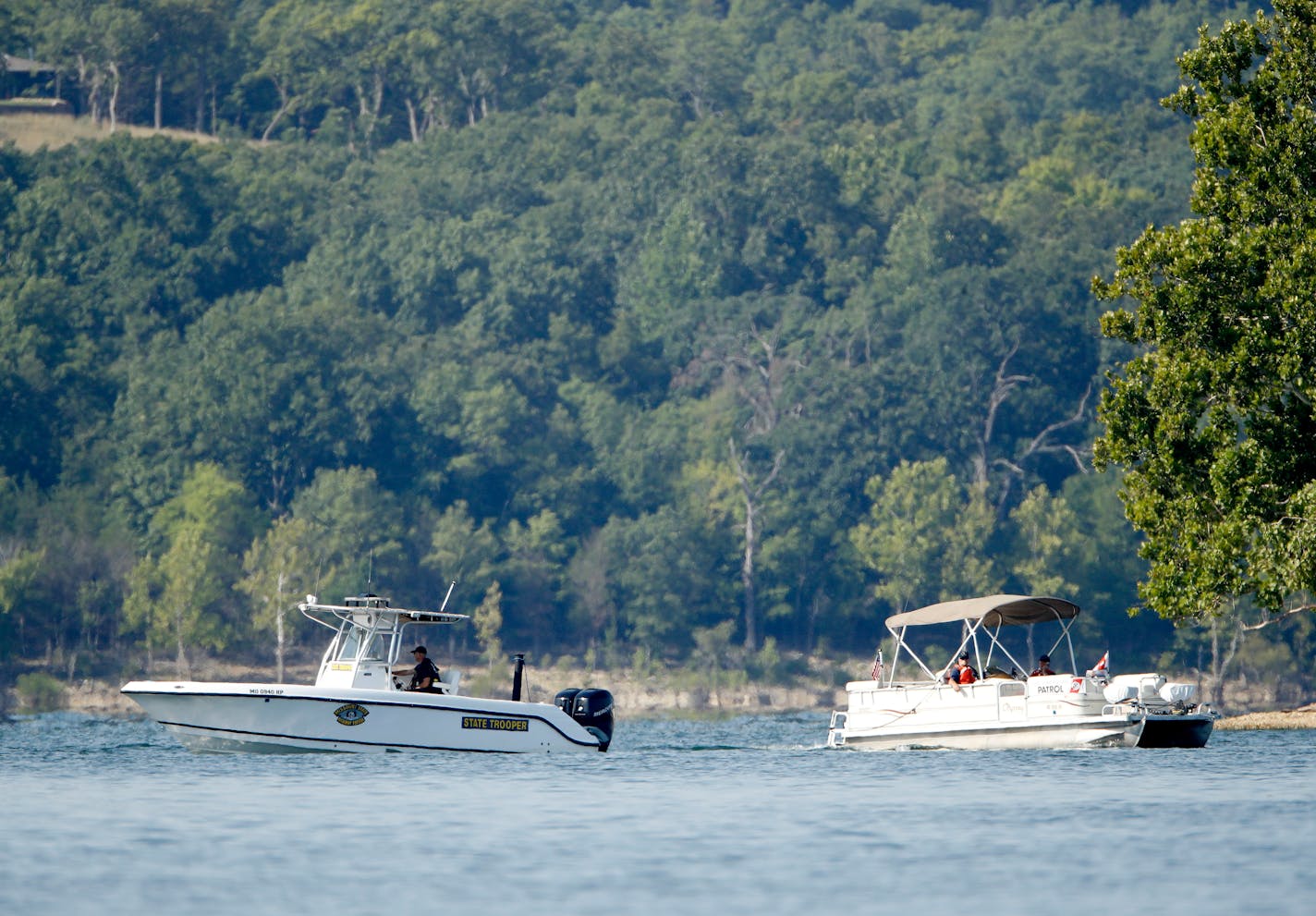 Emergency workers patrol an area Friday, July 20, 2018, near where a duck boat capsized the night before resulting in at least 13 deaths on Table Rock Lake in Branson, Mo. Workers were still searching for four people on the boat that were unaccounted for. (AP Photo/Charlie Riedel)