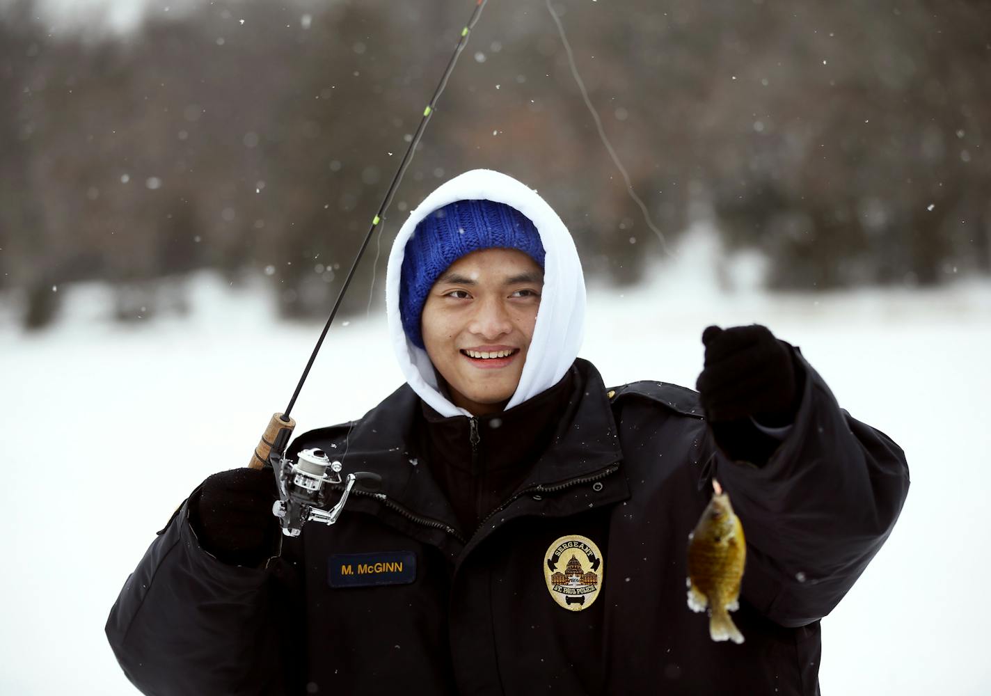 Moolahta Thaing 17, held up small sunfish during an ice fishing trip were St. Paul Police department took 10 Karen students from Washington High School on a ice fishing trip on Big Marine Lake Monday February 16, 2015 in Scandia, MN. ] Jerry Holt/ Jerry.Holt@Startribune.com