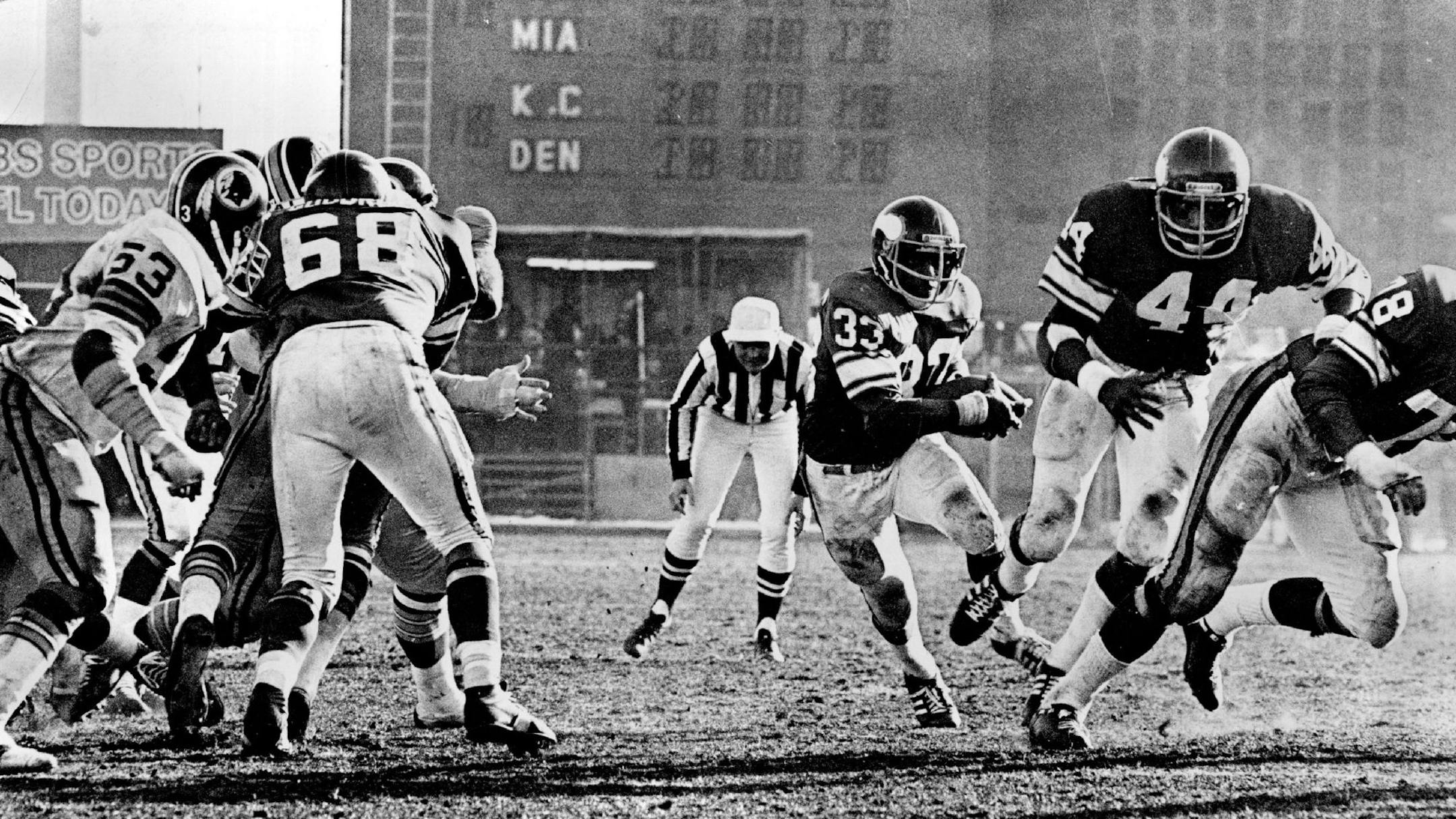 December 19, 1976 Brent McClanahan (33), who rushed for more than 100 yards, started through a gaping hole behind from Charles Goodrum (68), Chuck Foreman (44) and Steve Rilley (78). December 18, 1976 Minneapolis Star Tribune