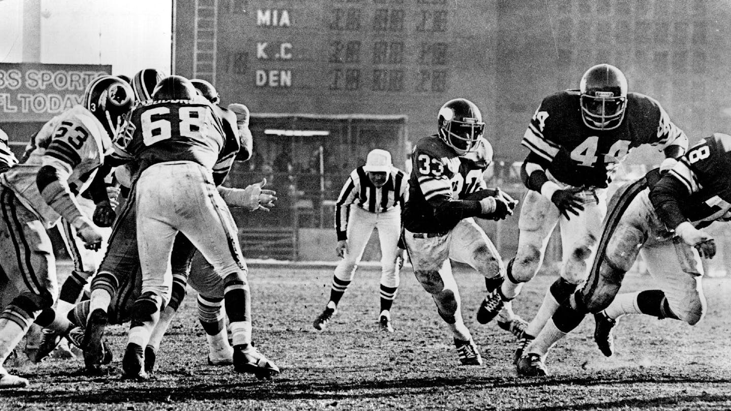 December 19, 1976 Brent McClanahan (33), who rushed for more than 100 yards, started through a gaping hole behind from Charles Goodrum (68), Chuck Foreman (44) and Steve Rilley (78). December 18, 1976 Minneapolis Star Tribune