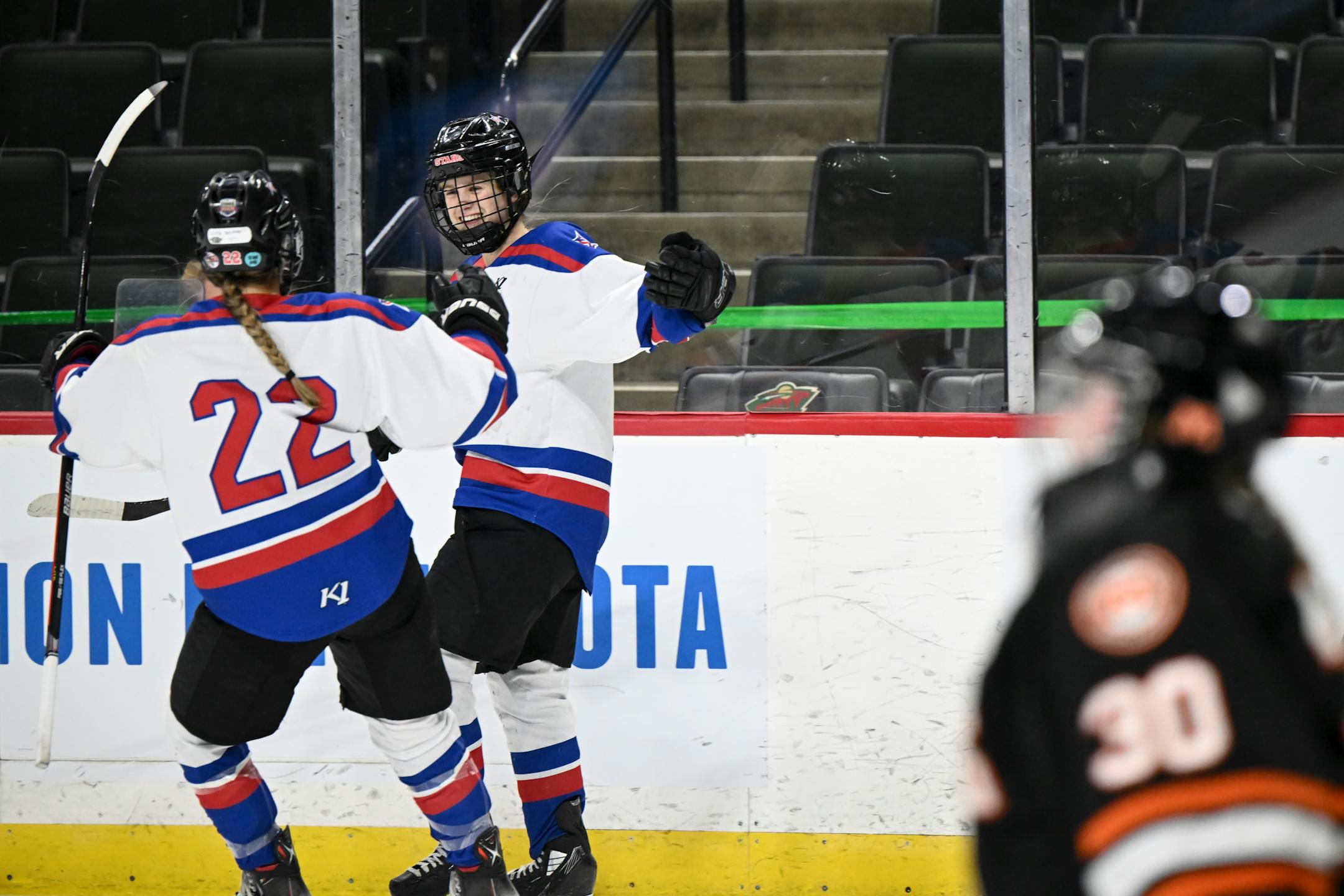 Gentry forward Grace Delmonico (22) celebrates with  forward Cara Sajevic (7) after Sajevic completed the hat trick against Moorhead during the first period.