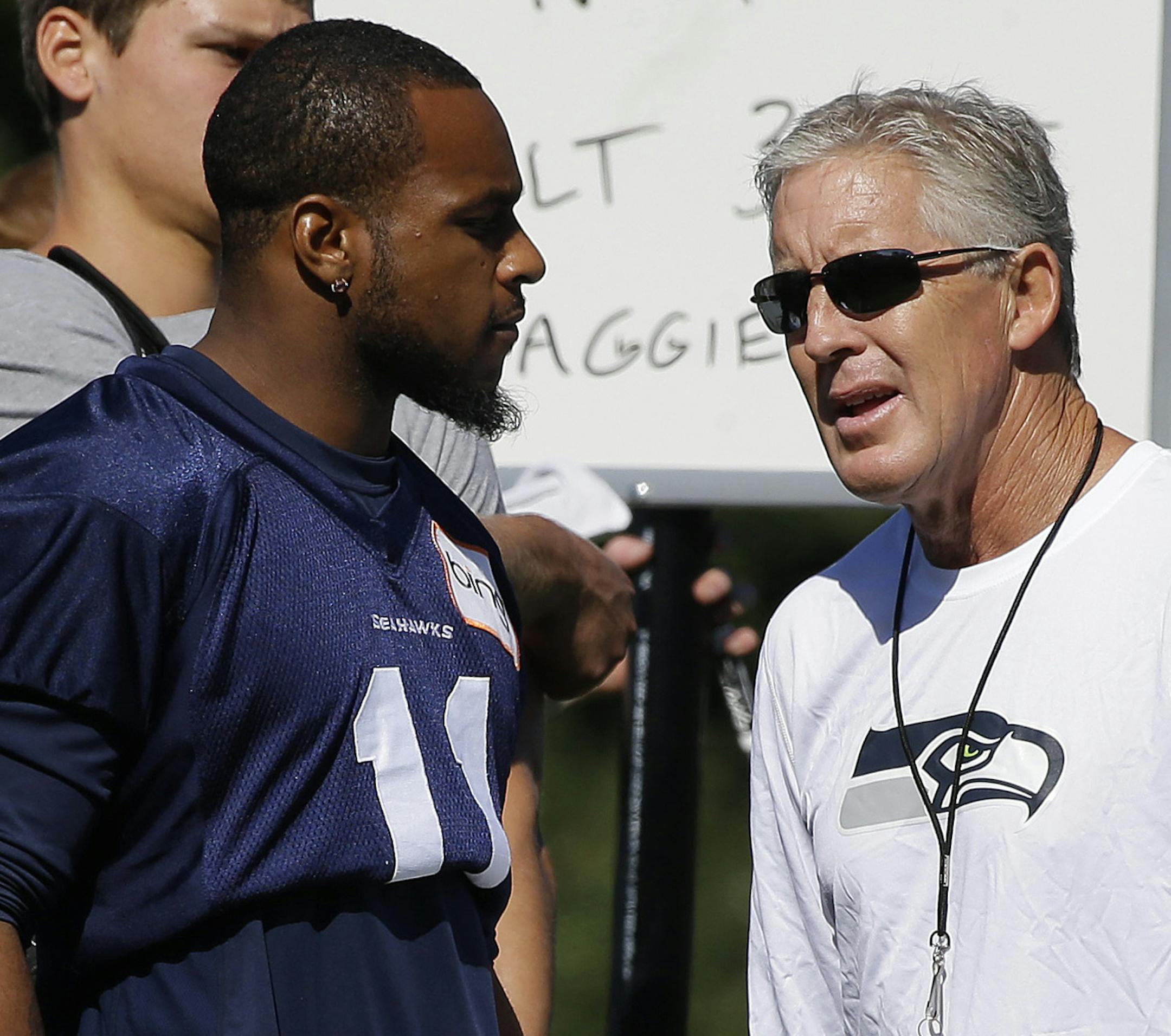 Seattle Seahawks wide receiver Percy Harvin, left, talks with head coach Pete Carroll, right, during NFL football training camp, Thursday, July 25, 2013, in Renton, Wash. Harvin has a hip injury that landed him on the physically unable to perform list for the first day of camp. (AP Photo/Ted S. Warren)