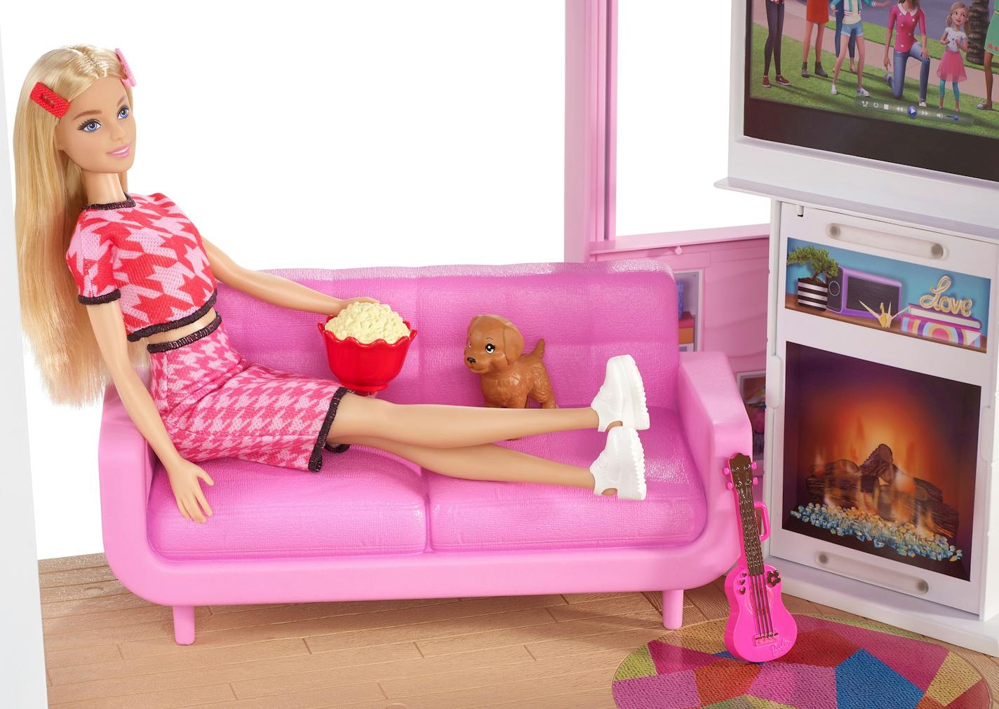 Barbie relaxes on the pink sofa in the latest Barbie Dreamhousse. MUST CREDIT: Mattel