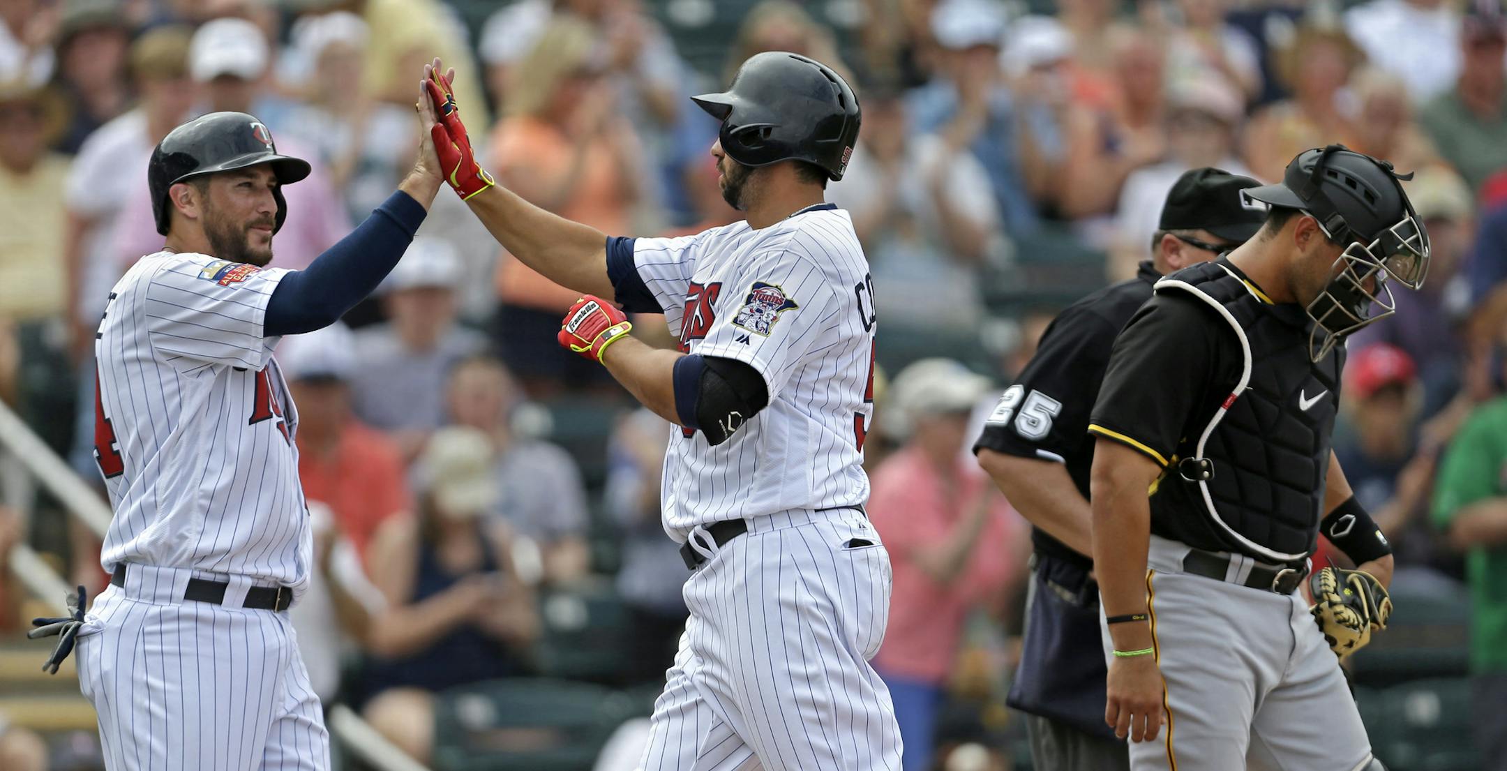 Minnesota Twins Chris Colabello, right, is greeted at the plate by Trevor Plouffe after the two scored in Colabello's two-run homer in the sixth inning of an exhibition baseball game against the Pittsburgh Pirates in Fort Myers, Fla., Wednesday, March 12, 2014. (AP Photo/Gerald Herbert)
