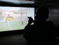 Mark Tulloch, of Kettering, Ohio, takes aim in a firearms training simulator at the Clark County Fair on Wednesday, July 26, 2017, in Springfield, Ohi