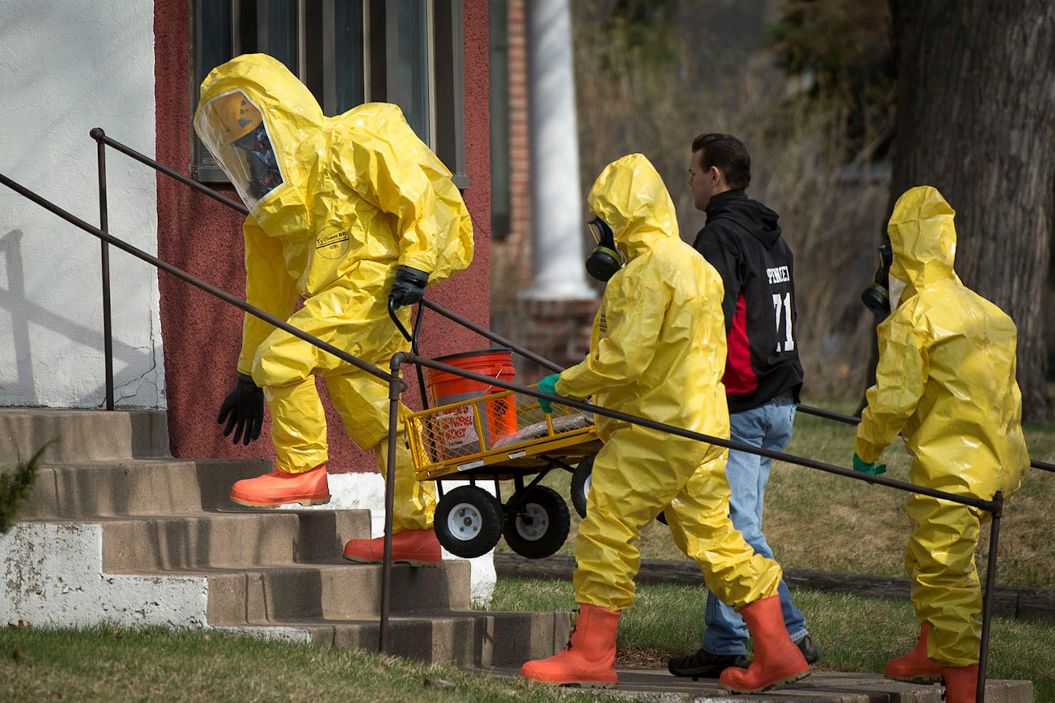 Hazardous material workers enter an apartment complex on the 500 block of 6th Street Southeast on Friday, April 10, 2015.
