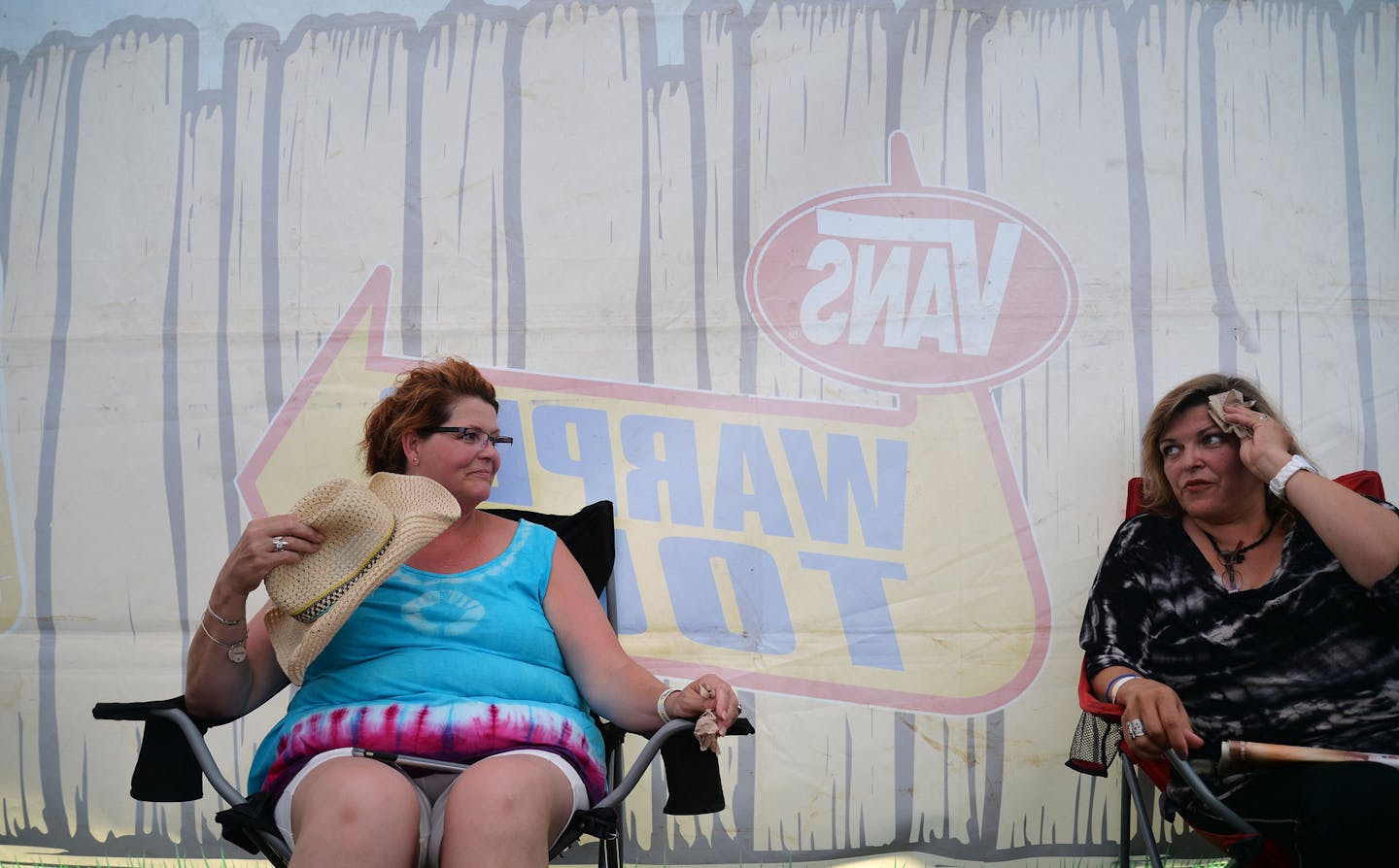 From left, Julie Wolf, of Wisconsin, looked at Maria Ahrndt, of Blaine, as she wiped sweat from her forehead while waiting in the "reverse daycare" tent for parents at Warped Tour in Shakopee, Minn., on Sunday July 26, 2015. ] RACHEL WOOLF &#xb7; rachel.woolf@startribune.com