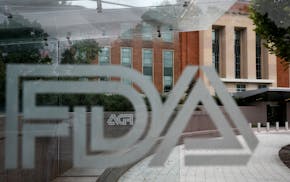 FILE - This Aug. 2, 2018 file photo shows the U.S. Food and Drug Administration building behind FDA logos at a bus stop on the agency's campus in Silv