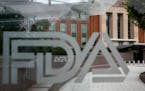FILE - This Aug. 2, 2018 file photo shows the U.S. Food and Drug Administration building behind FDA logos at a bus stop on the agency's campus in Silv