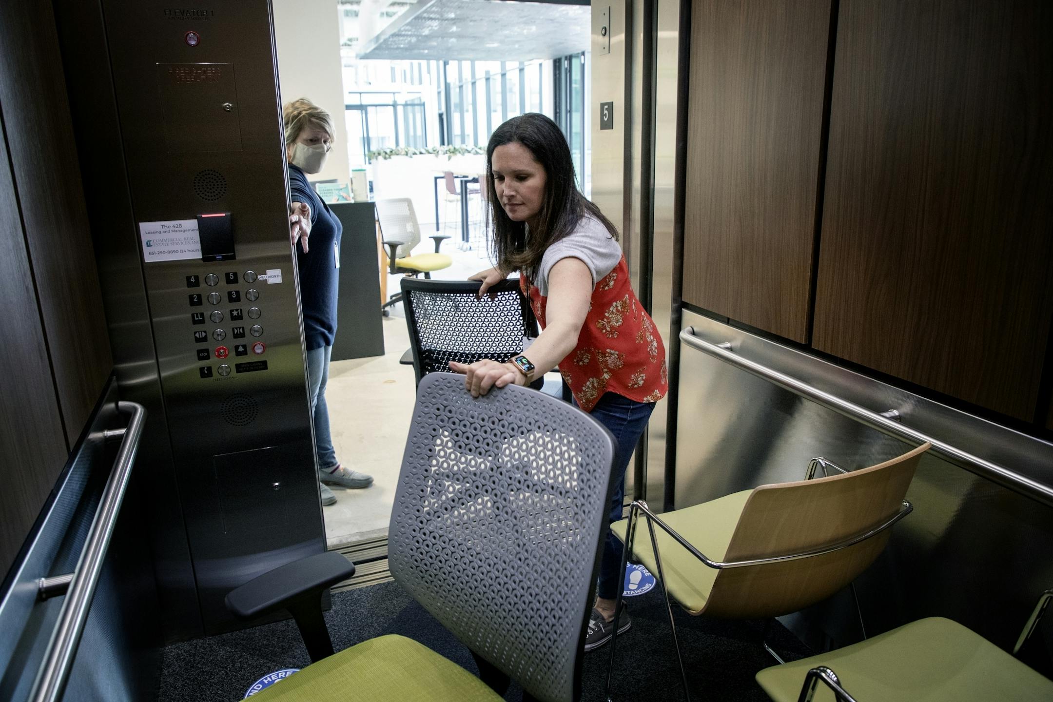 Jamie Rissi operations manager at Wellworth in St. Paul moved chairs in an elevator and out of the office to help space out working areas in preparation for reopening.