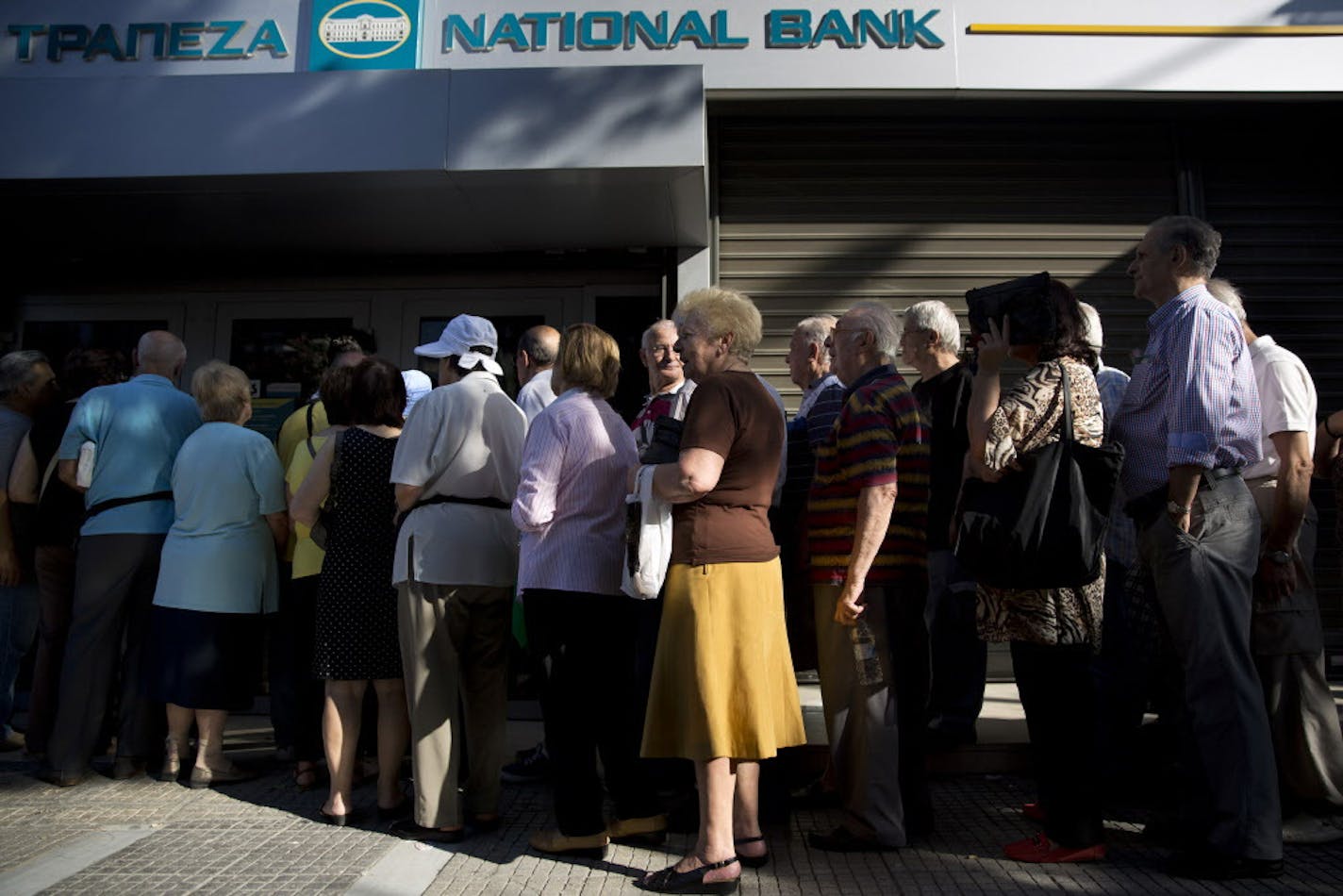 Pensioners line up as they wait to be allowed into a bank to withdraw a maximum of 120 euros ($134) for the week, Thursday, July 2, 2015. Greece braced for more chaos on the streets outside its mostly shuttered banks Thursday, as Athens and its creditors halted talks on resolving the country's deepening financial crisis until a referendum this weekend. (AP Photo/Petros Giannakouris)